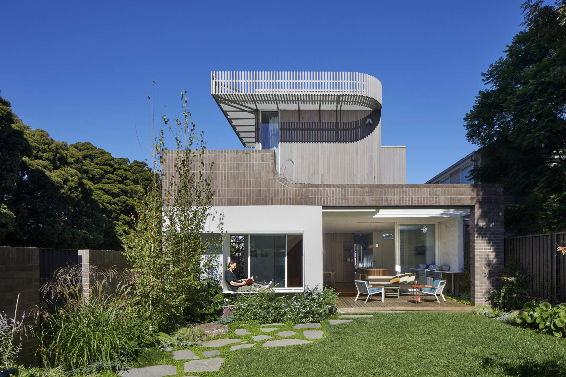 A compact Clifton Hill garden becomes an outdoor room with steppingstones, hidden water jets and a detached studio with its own bedroom, bathroom and kitchenette.