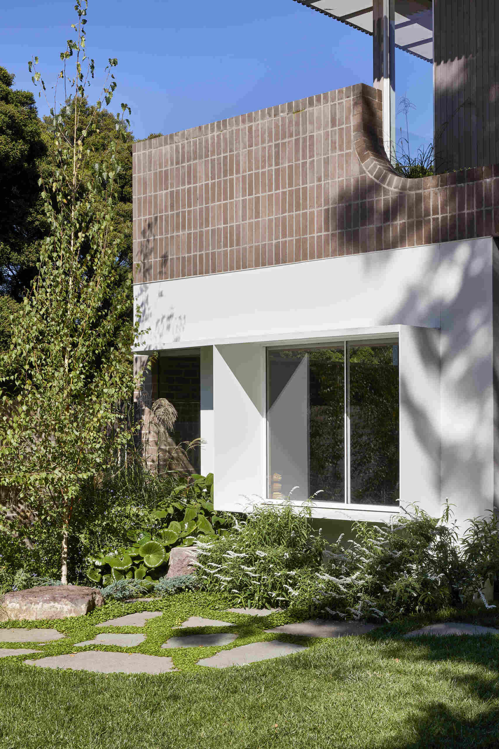 A compact Clifton Hill garden becomes an outdoor room with steppingstones, hidden water jets and a detached studio with its own bedroom, bathroom and kitchenette.