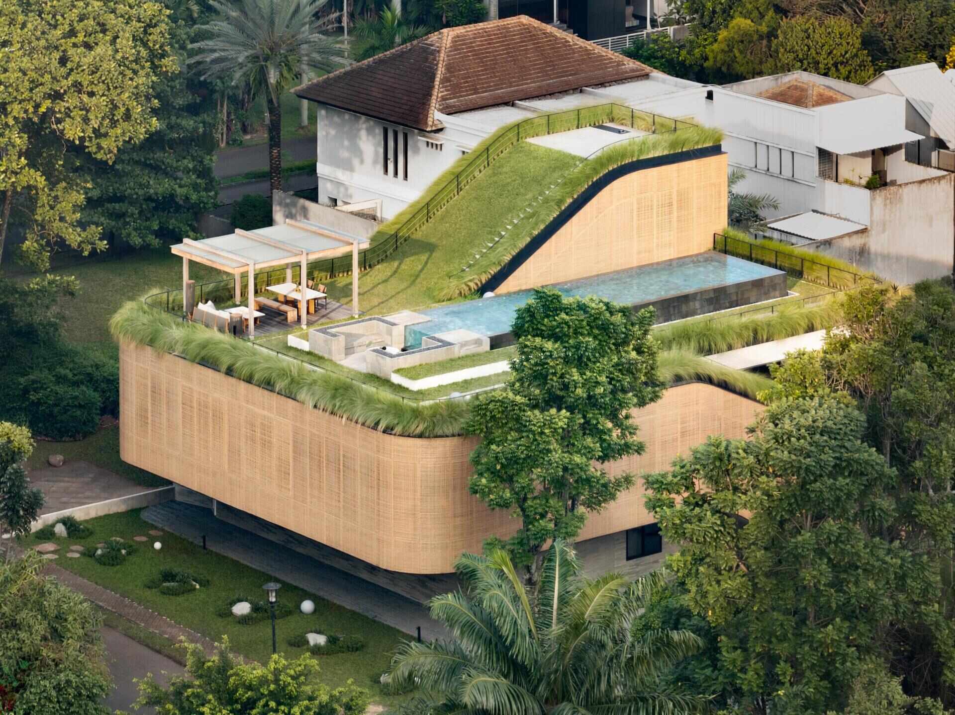 Split Mass Residence in Banten, Indonesia, by K-Thengono Design Studio combines a family home and office across multiple levels, with split volumes, courtyards, outdoor spaces and a rooftop pool.