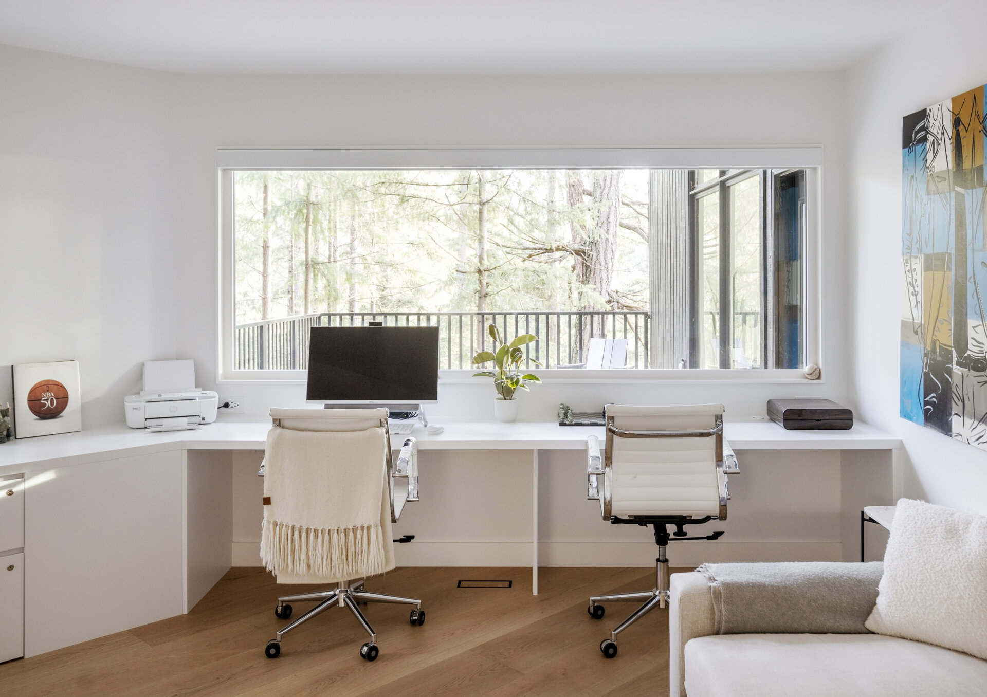 A former bedroom becomes a shared home office for the owners of Westport Place House, combining practical workspace with the warm material palette found throughout this West Vancouver renovation.