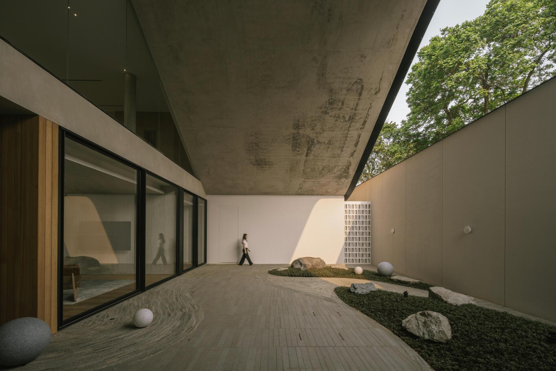 The ground floor of Split Mass Residence combines an office, meeting room, service areas and a garden arcade, creating a separate working zone within the family home.