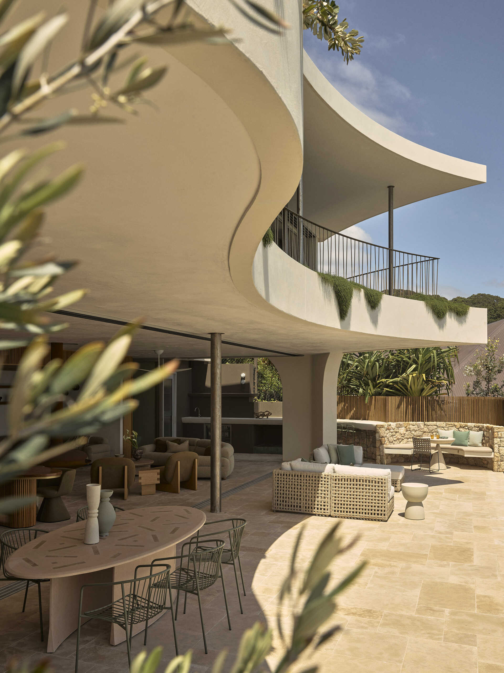 Take a look at the expansive outdoor terrace of this Wategos Beach home, where the main living spaces open directly outdoors and elevated gardens soften the multi-level architecture.