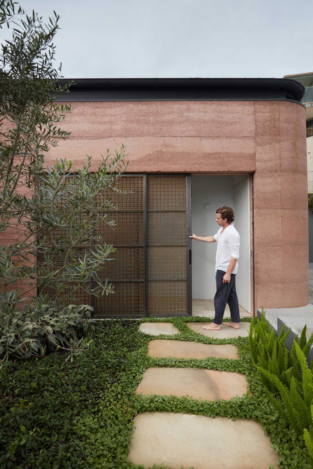 Warm rammed earth walls welcome visitors into Earth-Ship, a renovated Sydney home by Luigi Rosselli Architects. Discover the earthy entrance, landscaped courtyard and architectural details of this unusual Australian house.