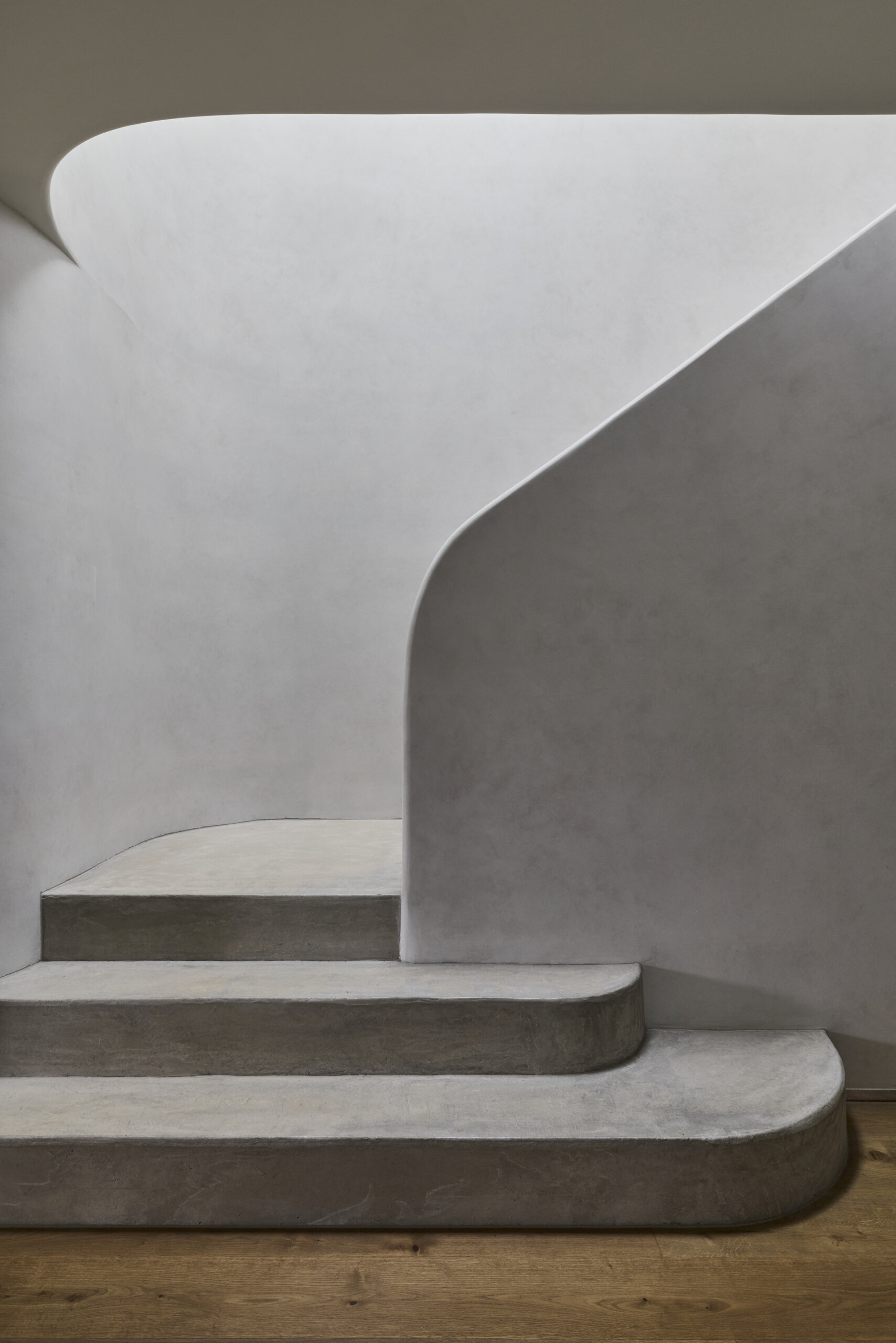 Explore the staircase at Sasso Nero, curved forms and natural light from overhead skylights bring architectural detail to the transition between levels.