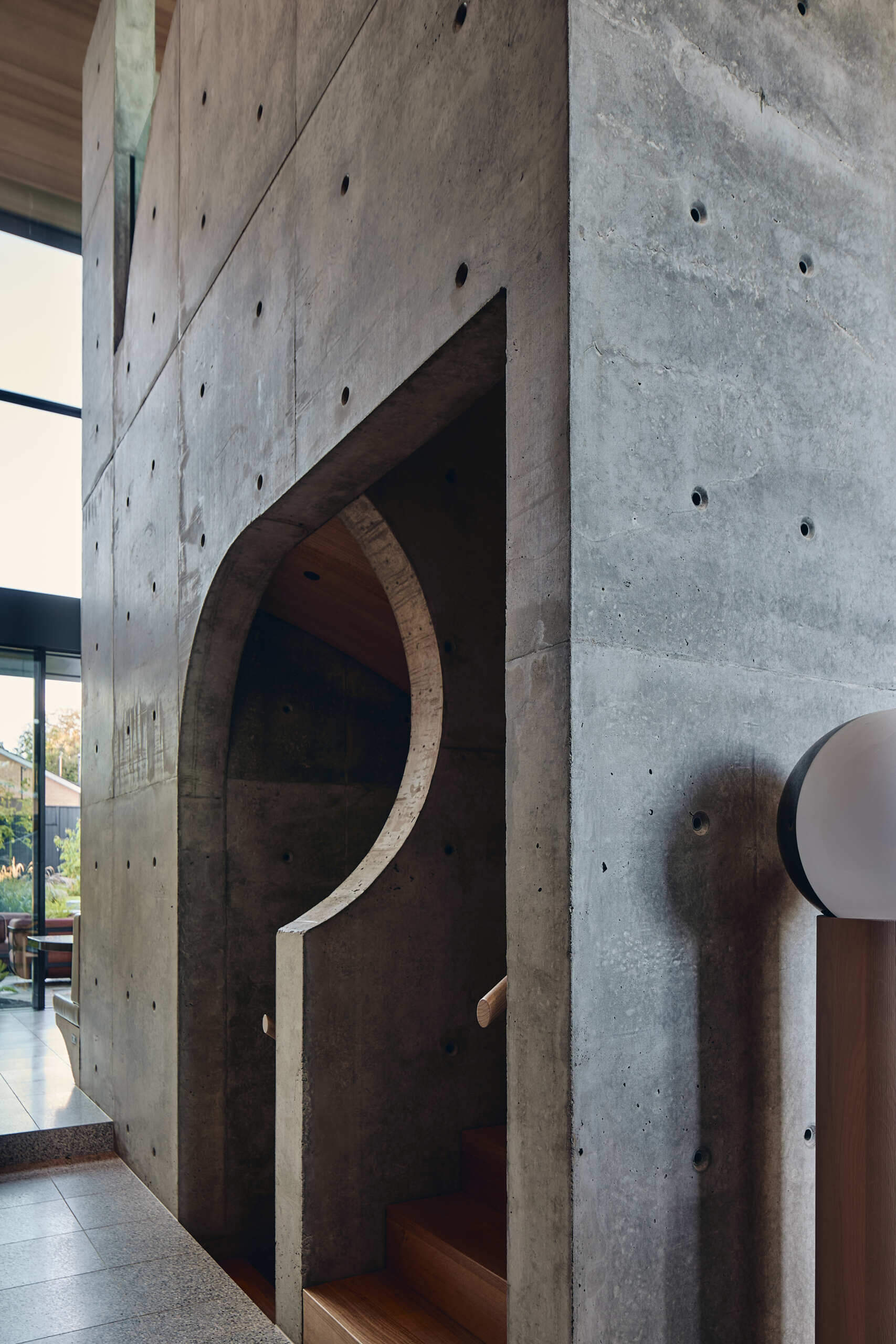 The stairs and double-height central volume at Babylonia connect the different layers of this Melbourne home, with concrete walls rising through the interior beneath the garden terraces.