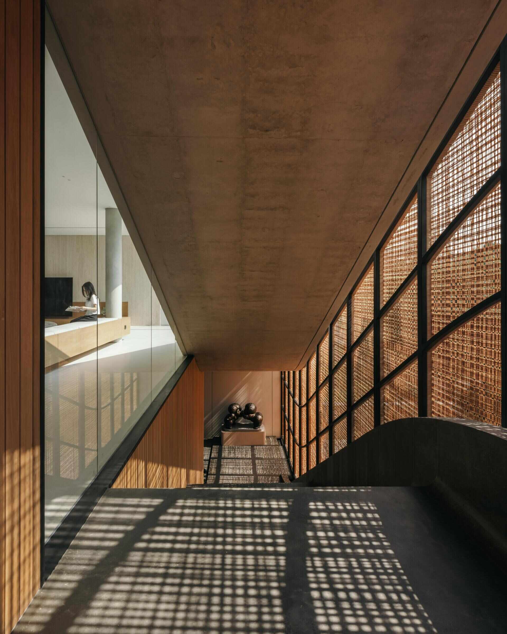 A modern house with stairs that run alongside woven screens.