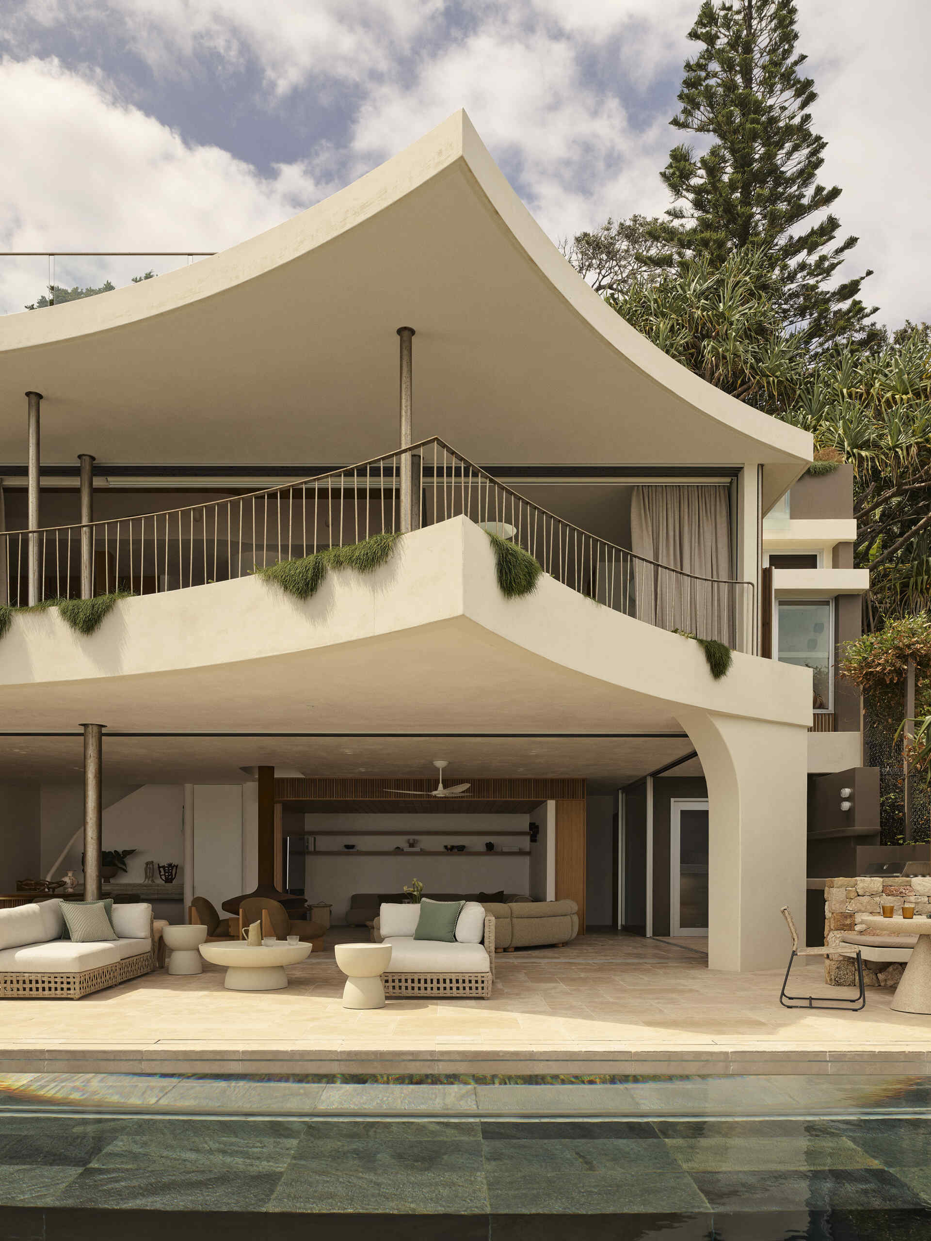 Take a look at the expansive outdoor terrace of this Wategos Beach home, where the main living spaces open directly outdoors and elevated gardens soften the multi-level architecture.