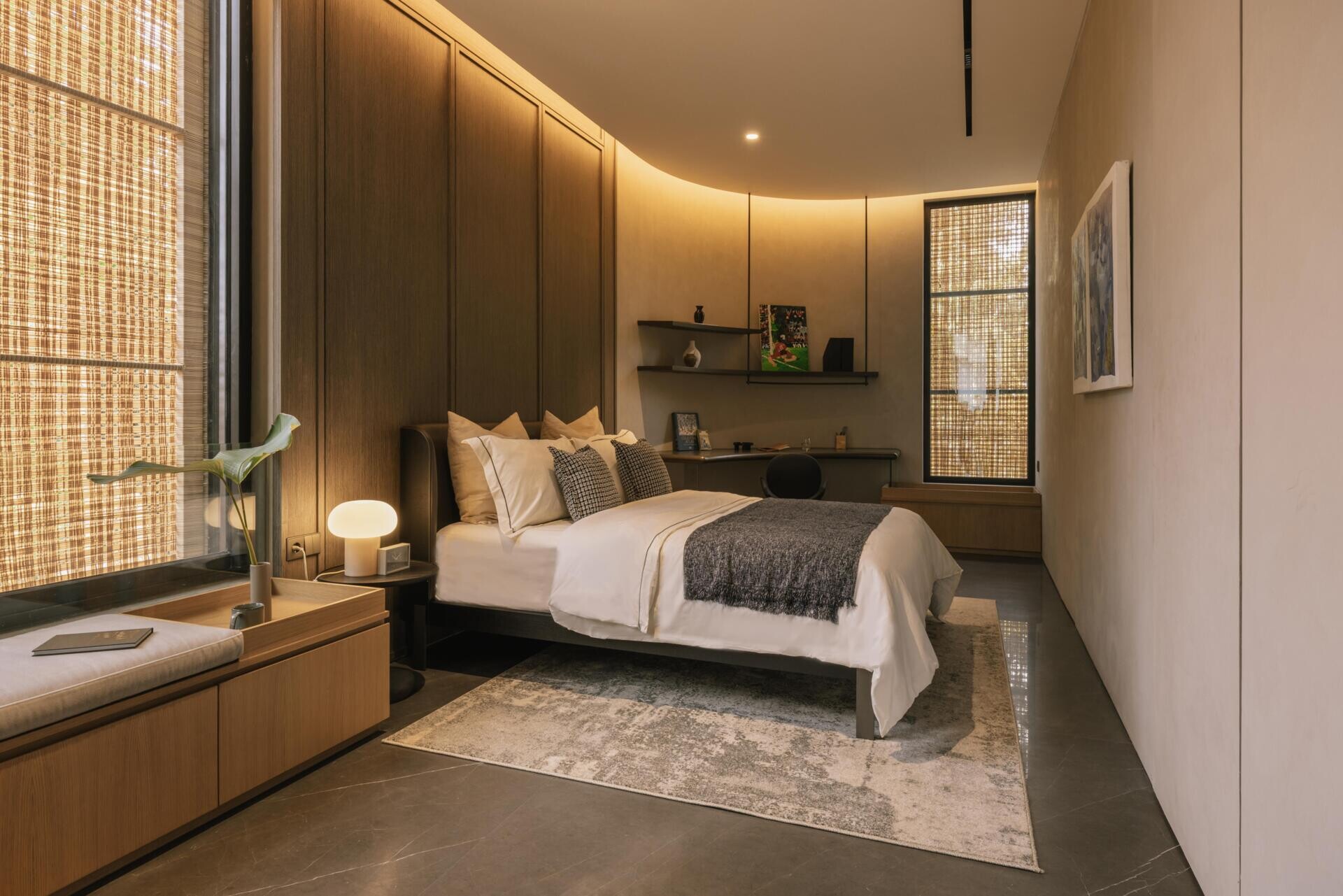 A modern kid's bedroom with a curved wall, hidden lighting, and a window bench.