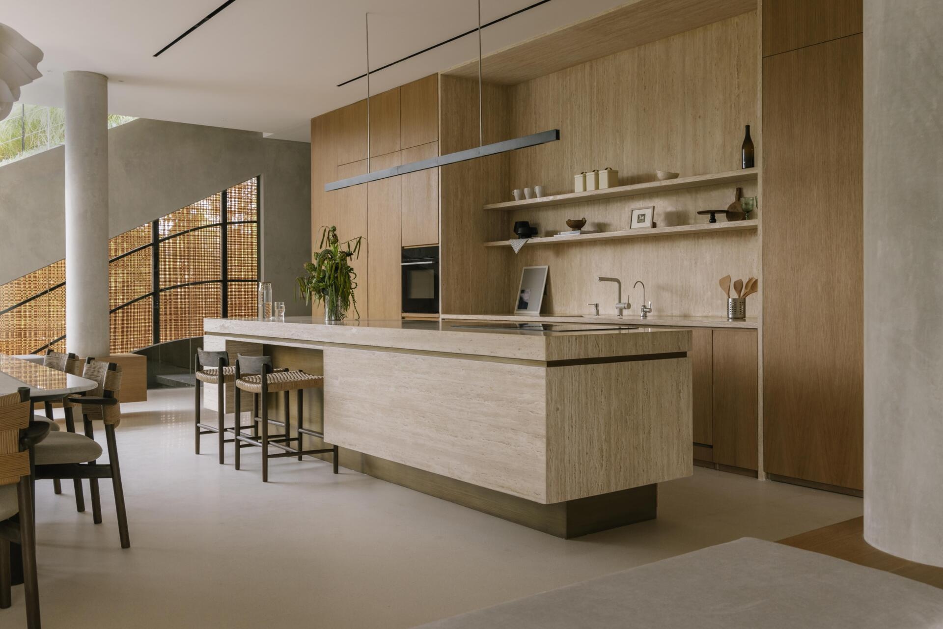 A modern kitchen with a large island and wood cabinets.