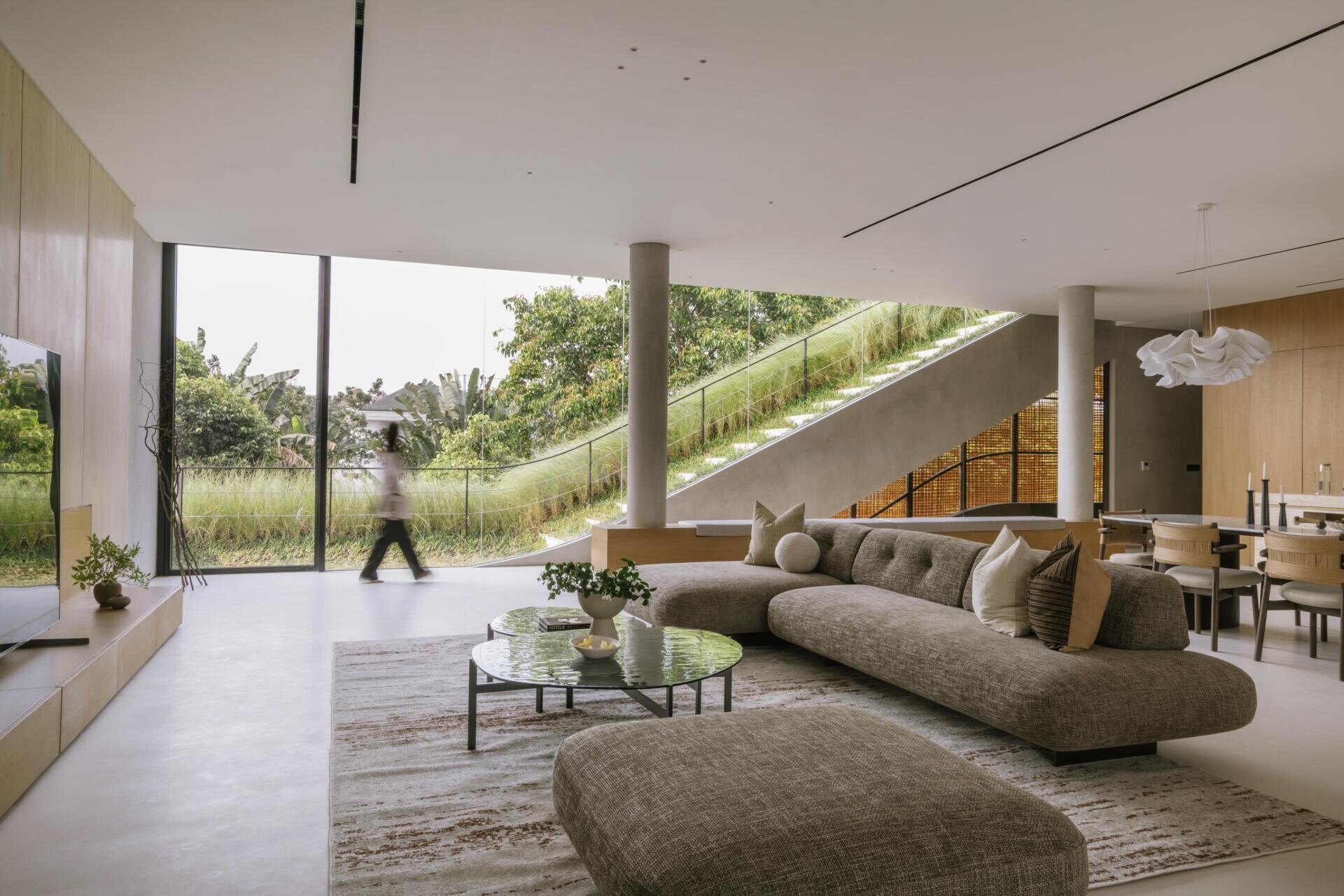 Take a look inside the private first floor of Split Mass Residence, with a living room, dining area, kitchen and entertainment discussion area arranged alongside the family bedrooms.