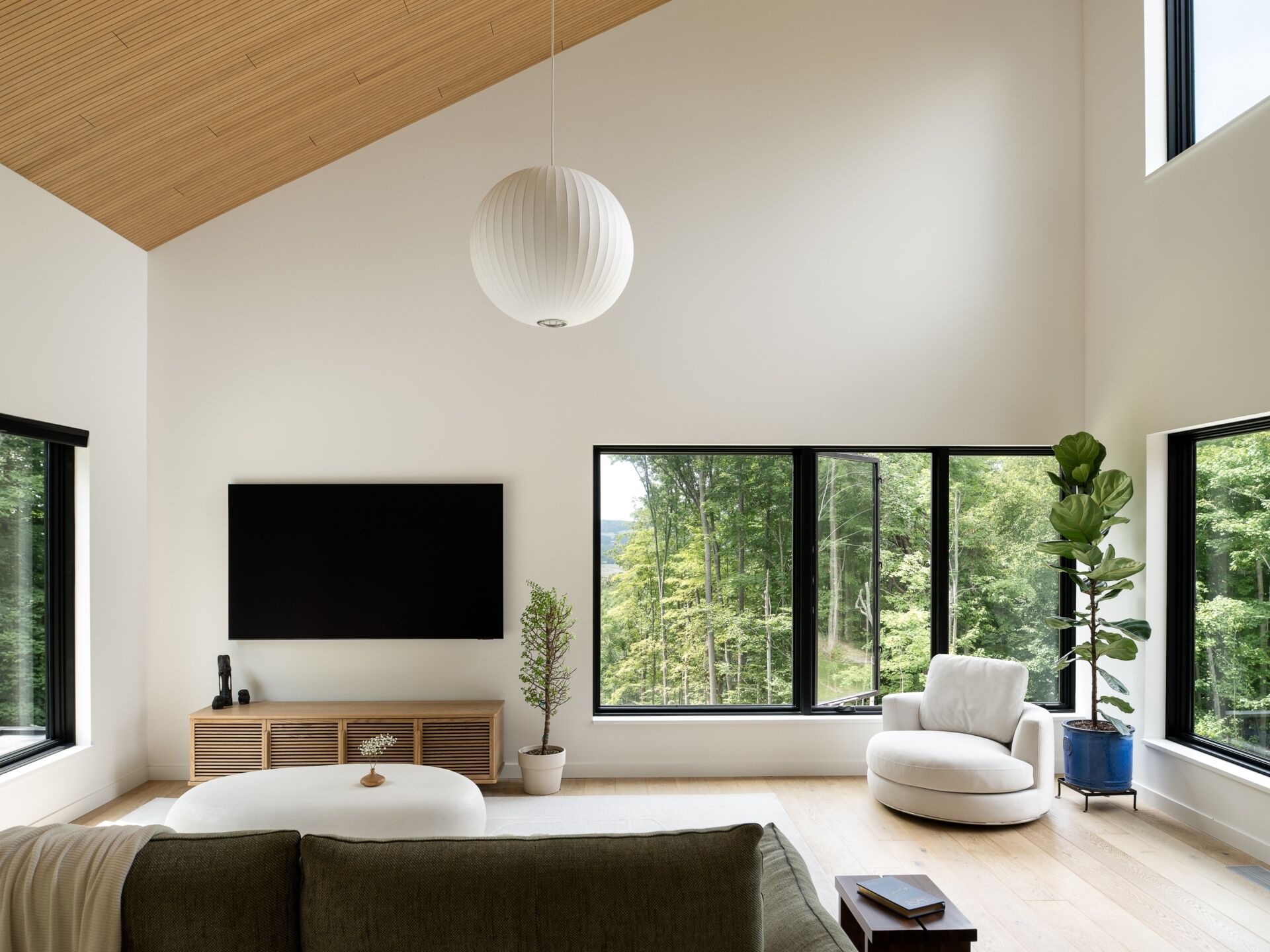 See inside the soaring living room of the Milo House, where cathedral-like ceilings, natural light, pale wood and views toward the Adirondacks create an airy interior.