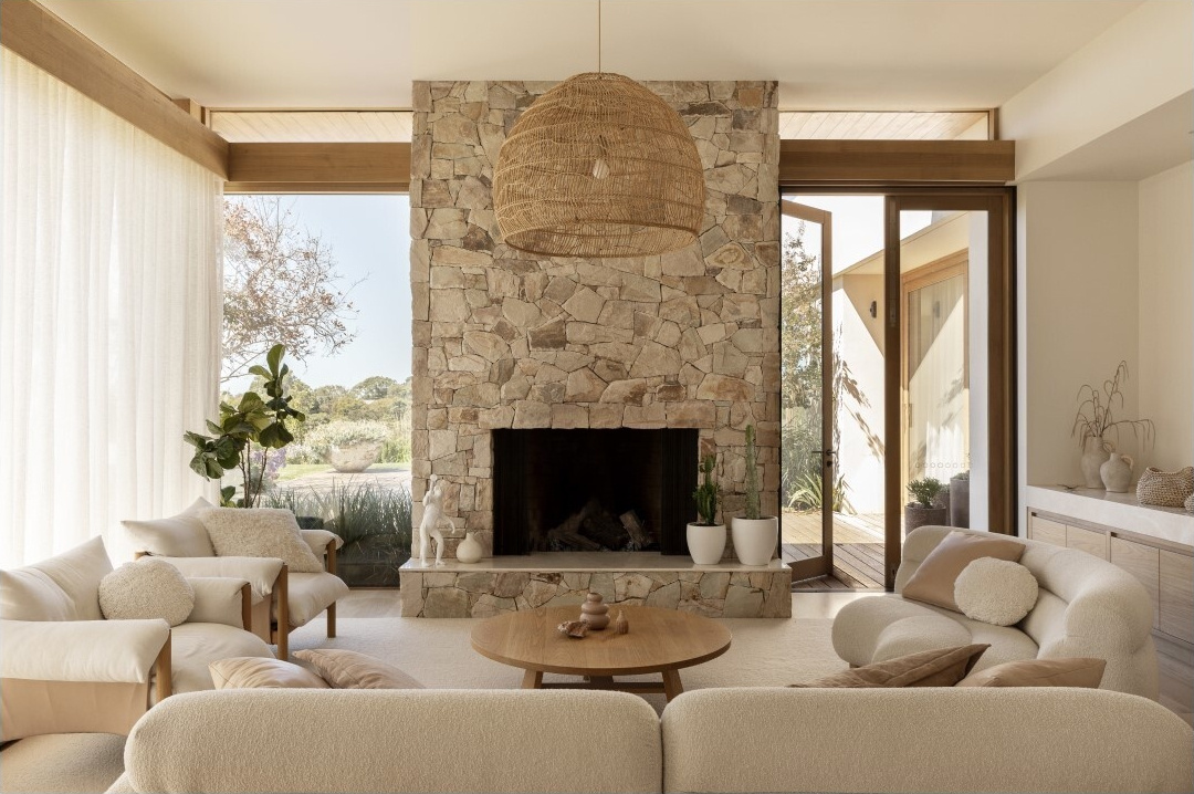 The living and dining spaces form part of the home's generous open areas, designed to support entertaining and gathering. Large openings extend these rooms towards the surrounding landscape, bringing views of the valley and ocean into the interiors.