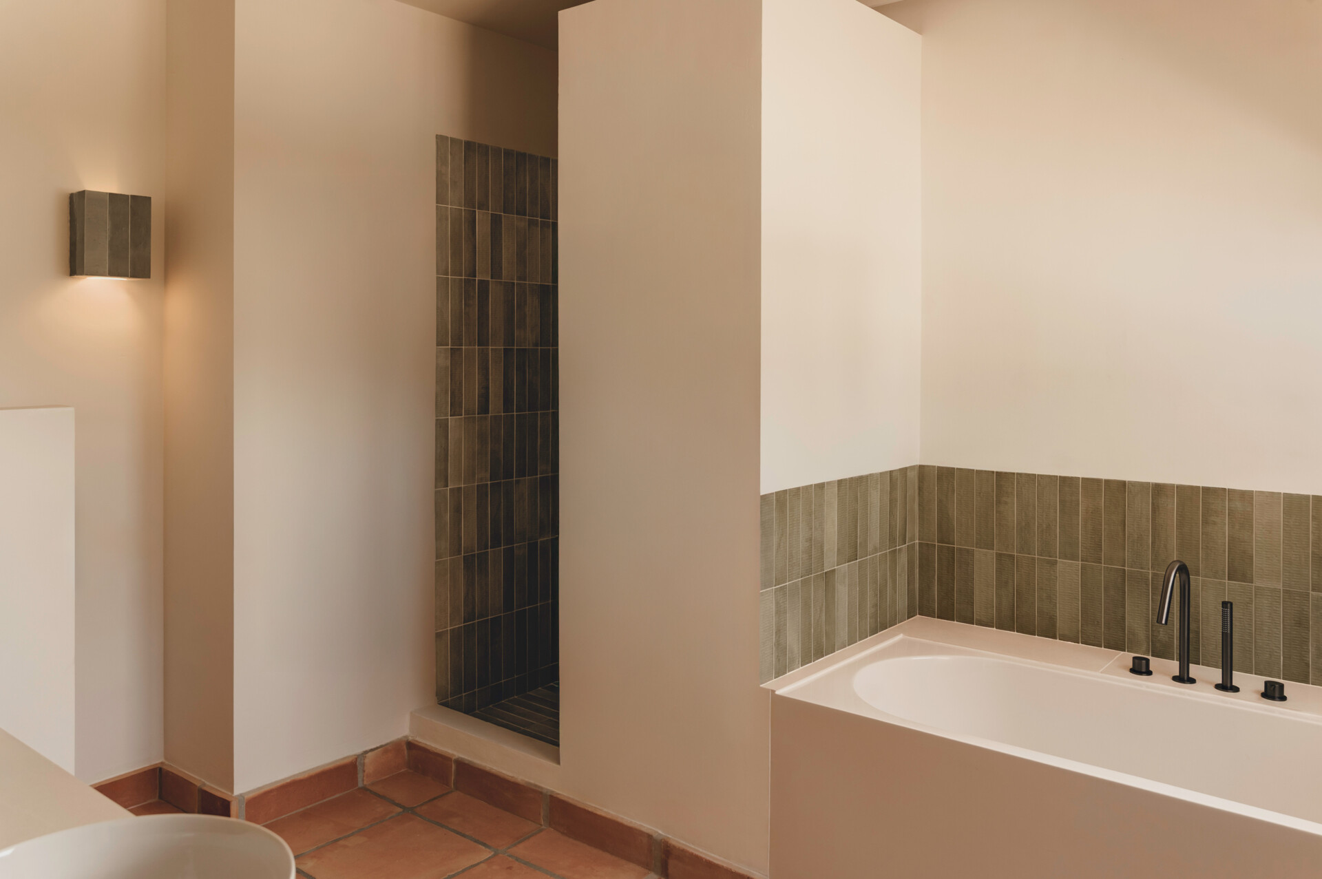 Textured ceramic walls, custom lighting and warm finishes make these Mediterranean bathrooms full of character.