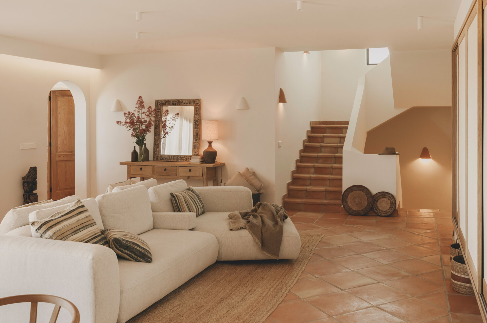Custom oak furniture, rattan details and linen-filtered light give this Mediterranean living room a calm, timeless appeal.