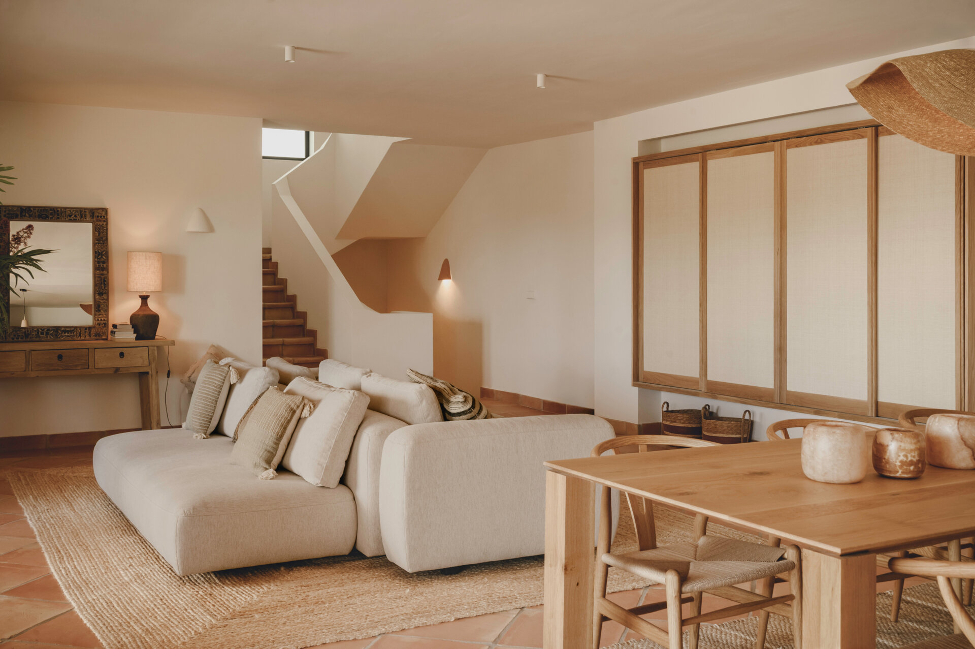 Custom oak furniture, rattan details and linen-filtered light give this Mediterranean living room a calm, timeless appeal.
