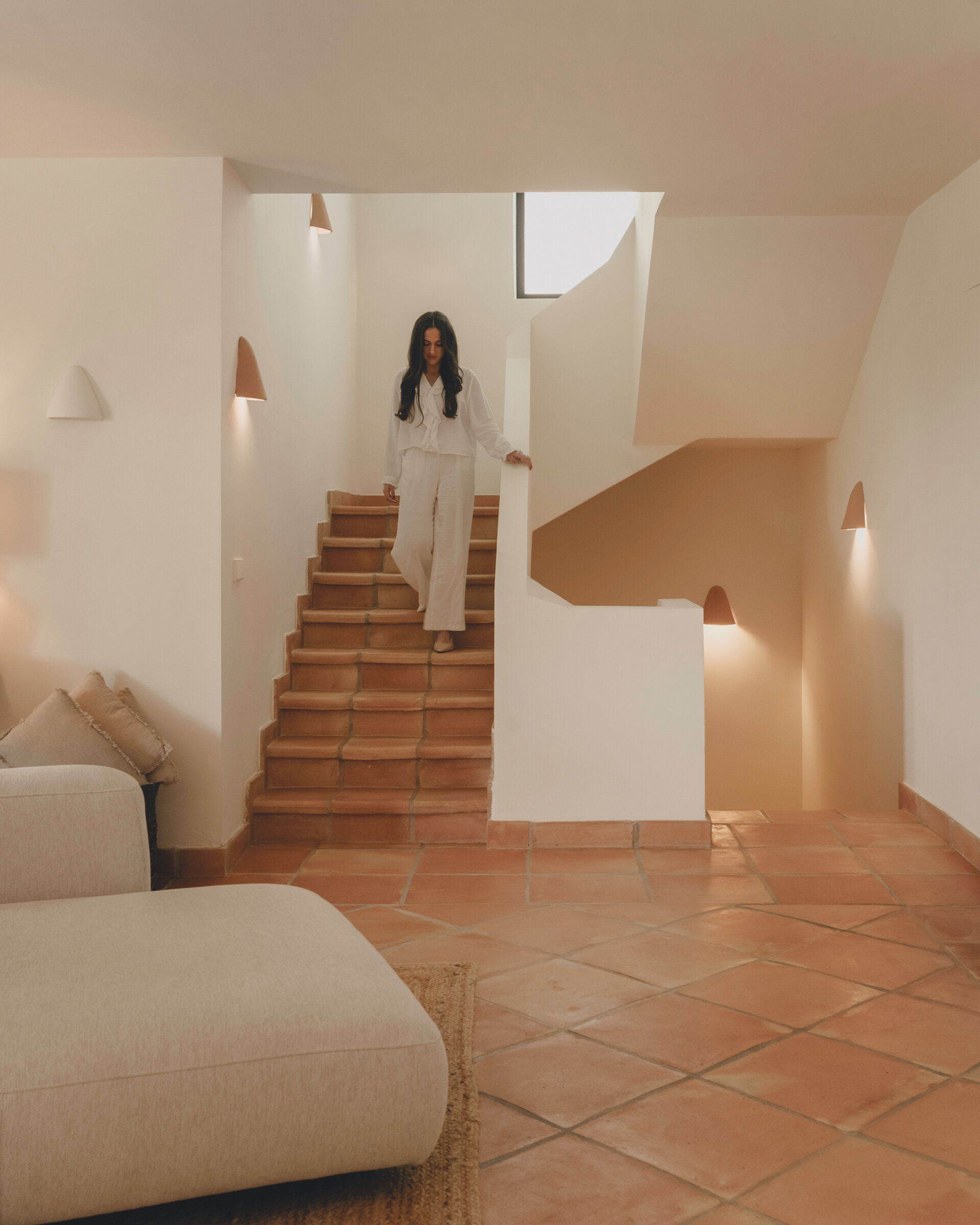The staircase continues the home's terracotta palette, creating a seamless connection between every level.