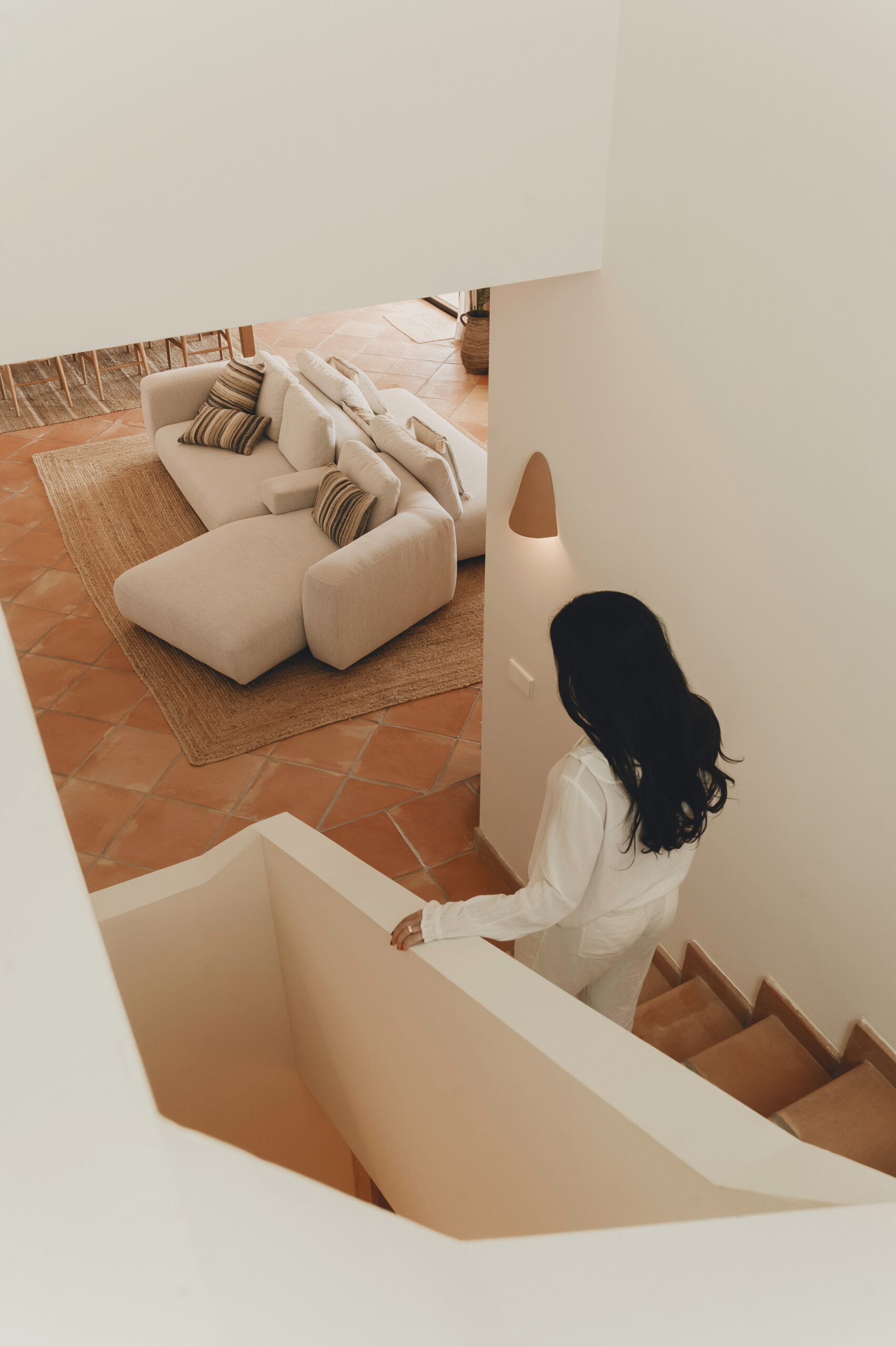 The staircase continues the home's terracotta palette, creating a seamless connection between every level.
