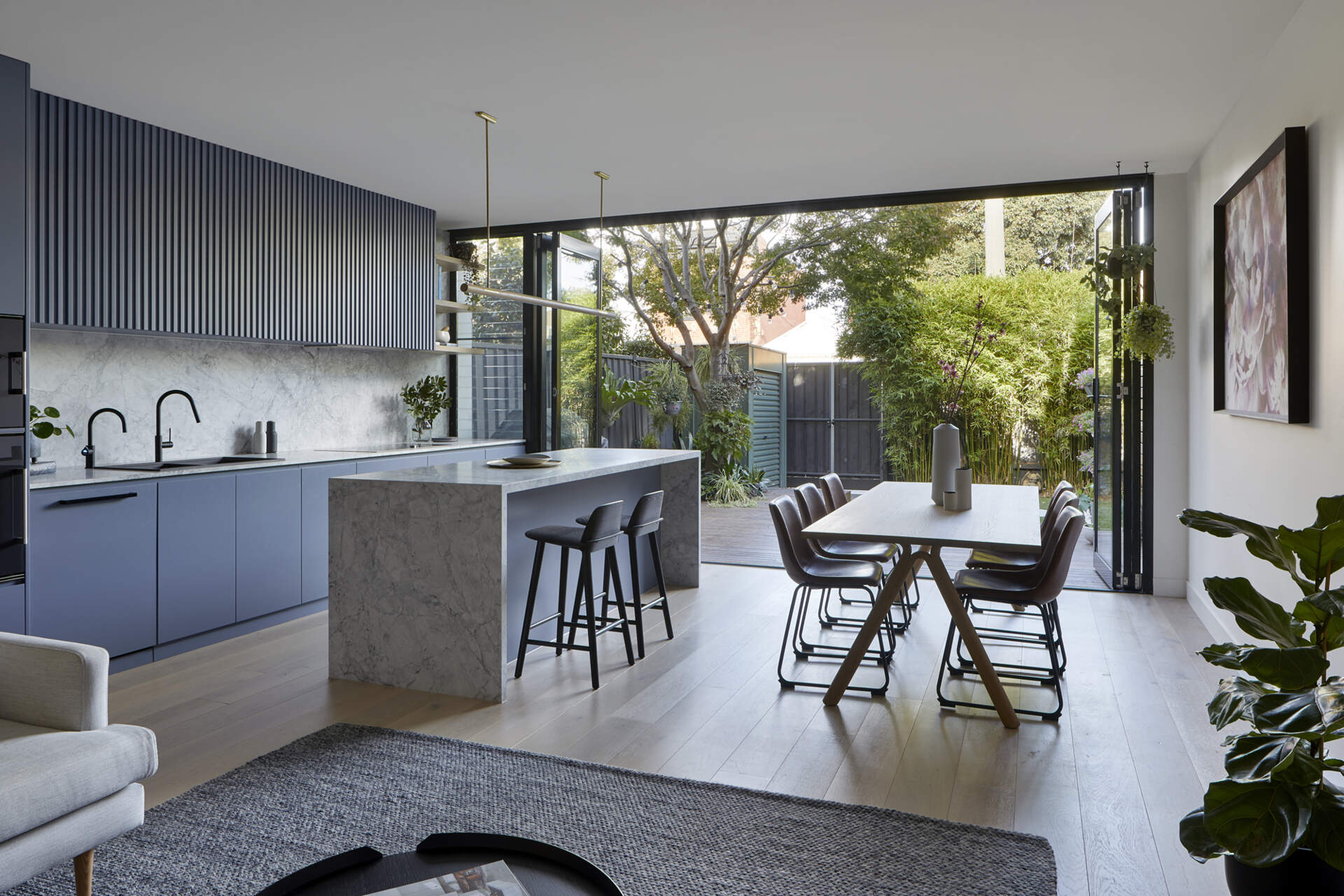 This Port Melbourne cottage opens from a traditional hallway into a bright open-plan living, dining, and kitchen space filled with light.