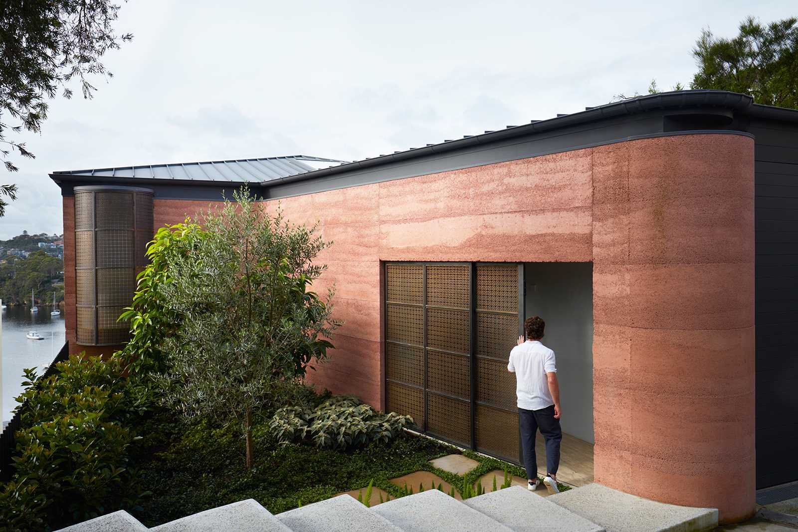 Warm rammed earth walls welcome visitors into Earth-Ship, a renovated Sydney home by Luigi Rosselli Architects. Discover the earthy entrance, landscaped courtyard and architectural details of this unusual Australian house.