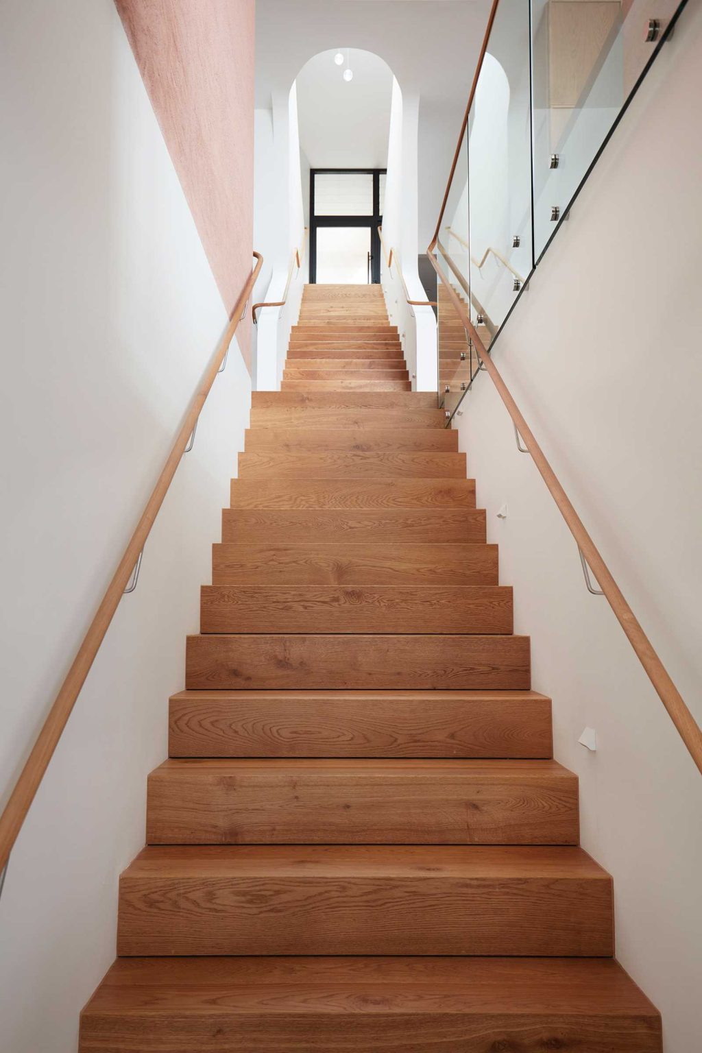 A linear staircase travels through multiple levels of Earth-Ship, with a deep void and large skylight bringing natural light down into the Sydney home designed by Luigi Rosselli Architects.