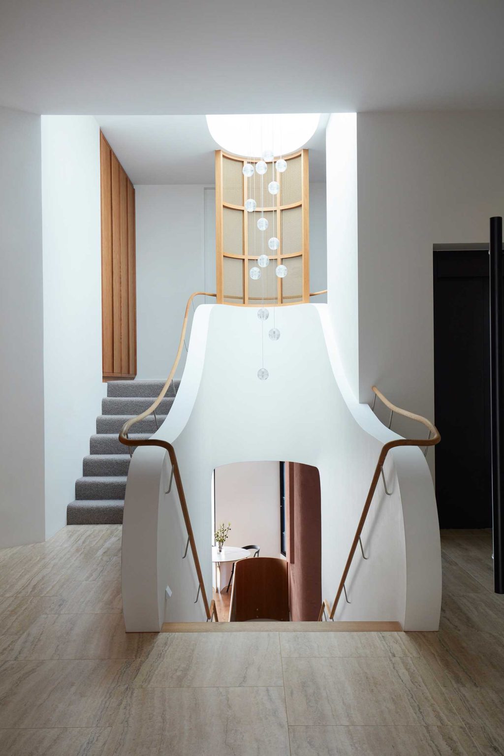 A linear staircase travels through multiple levels of Earth-Ship, with a deep void and large skylight bringing natural light down into the Sydney home designed by Luigi Rosselli Architects.