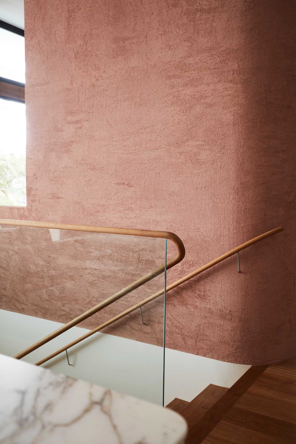 A linear staircase travels through multiple levels of Earth-Ship, with a deep void and large skylight bringing natural light down into the Sydney home designed by Luigi Rosselli Architects.
