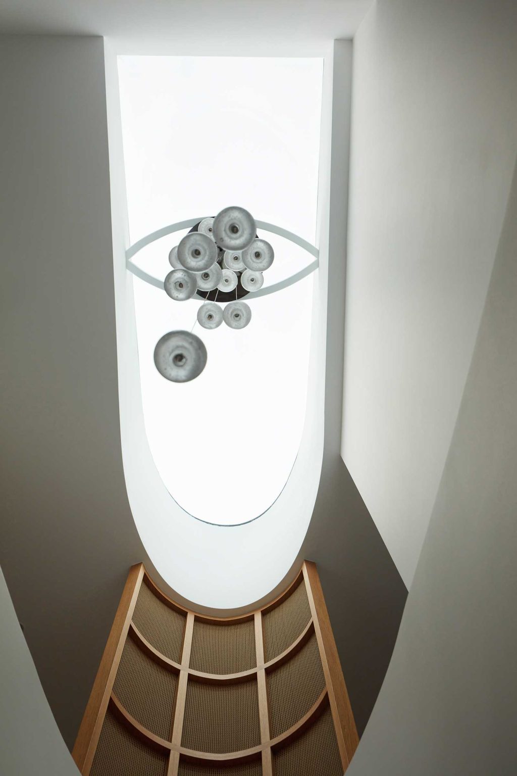 A linear staircase travels through multiple levels of Earth-Ship, with a deep void and large skylight bringing natural light down into the Sydney home designed by Luigi Rosselli Architects.