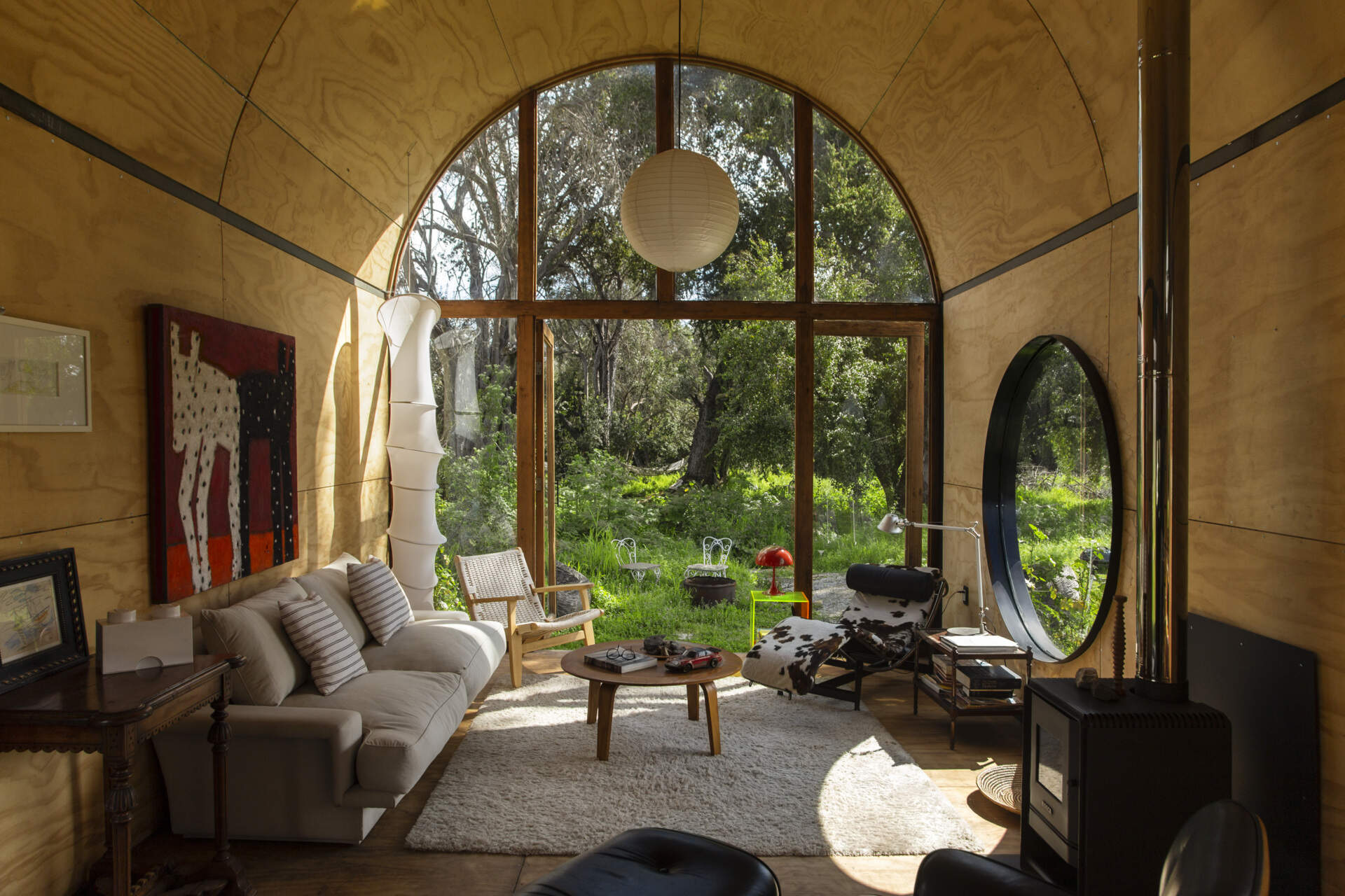 Catalejo by Tololo Ugarte is a circular tiny house elevated above the ground so seasonal grasses can grow beneath it, while its shape frames a forest of centuries-old trees.