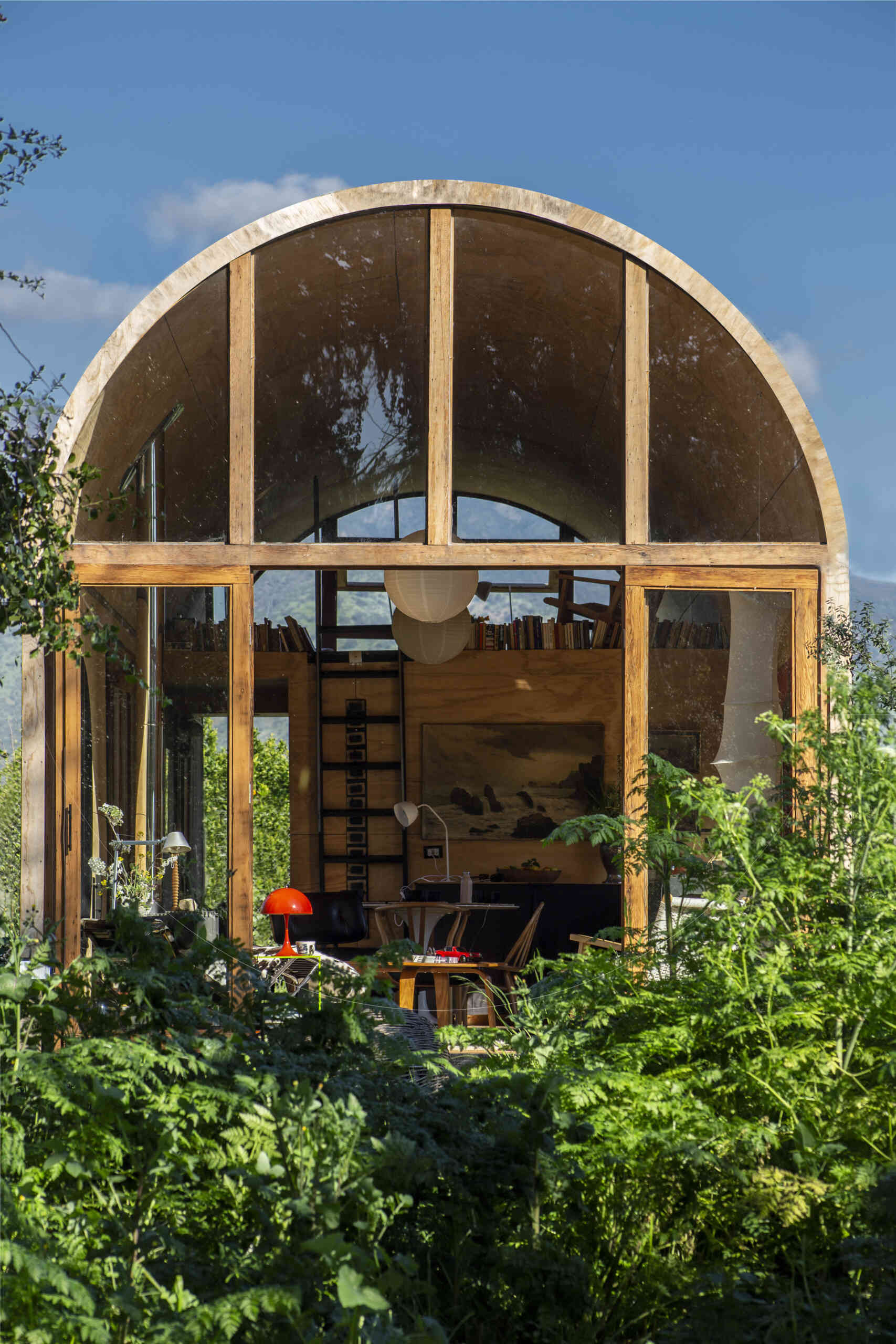 Catalejo by Tololo Ugarte is a circular tiny house elevated above the ground so seasonal grasses can grow beneath it, while its shape frames a forest of centuries-old trees.