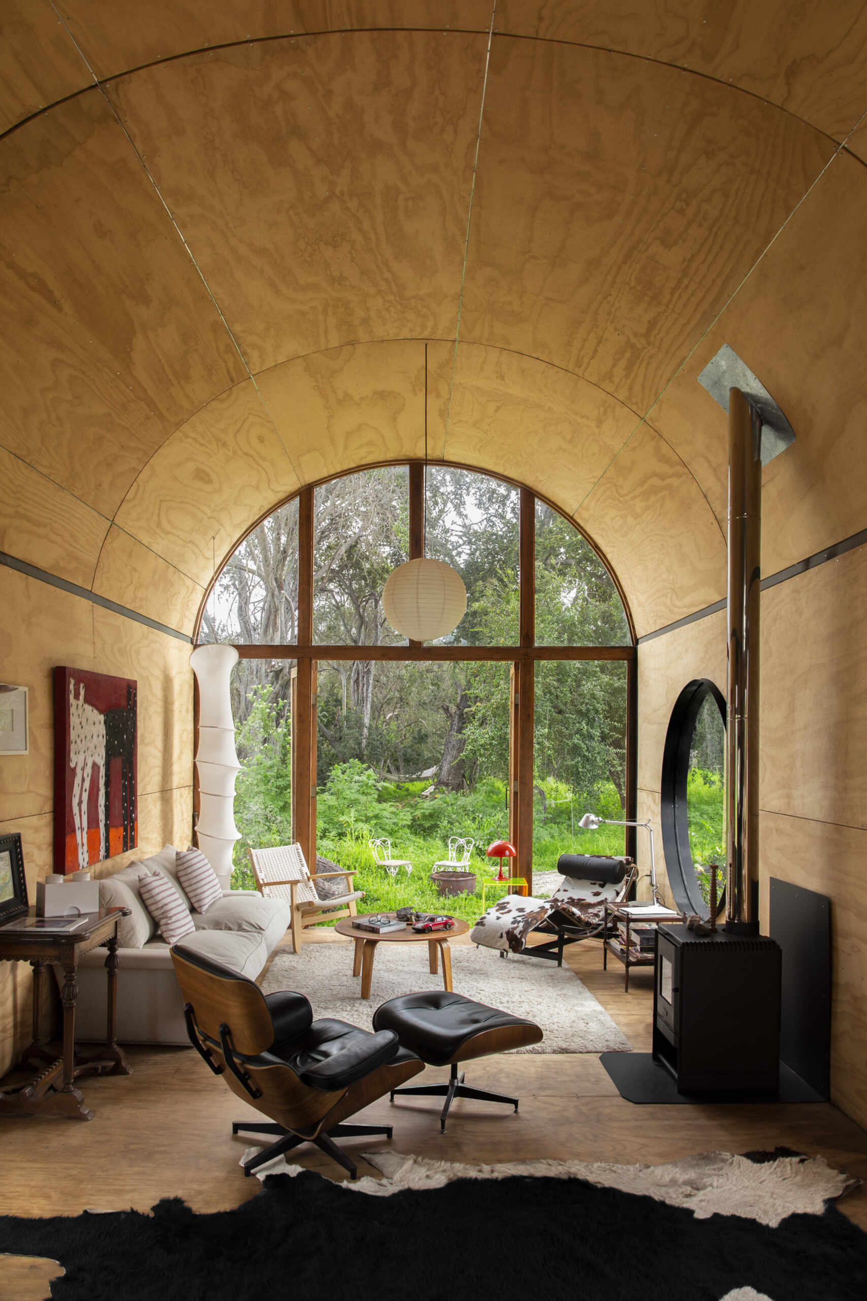 The living area in Catalejo uses double-height ceilings and expansive views to make a compact tiny house feel open and immersed in nature.