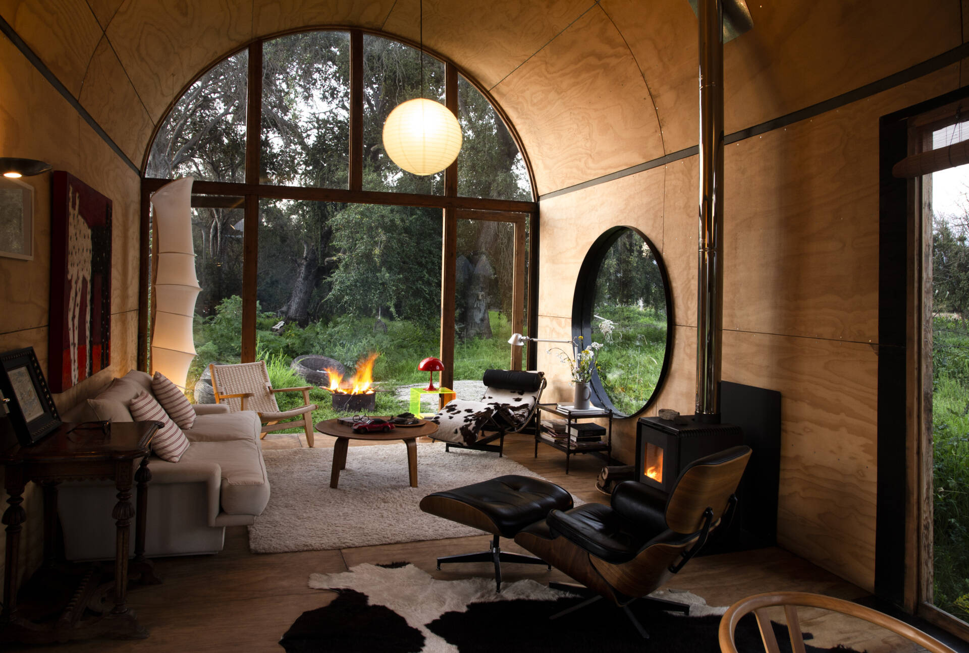 The living area in Catalejo uses double-height ceilings and expansive views to make a compact tiny house feel open and immersed in nature.