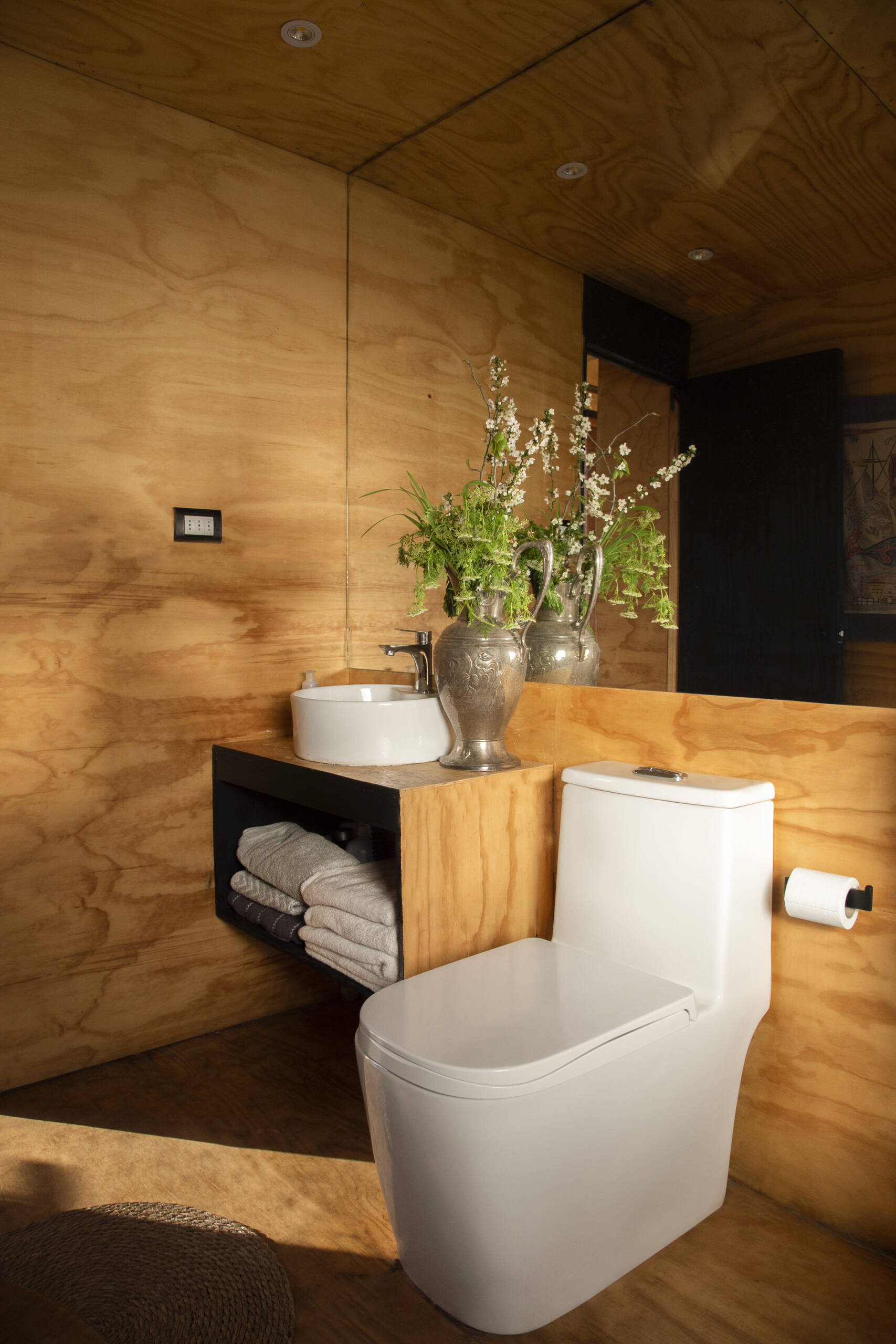 Even functional spaces are part of the overall concept. The bathroom in this tiny house, with its wood walls, also includes a large mirror, allowing the small room to feel much larger than its physical dimensions suggest.