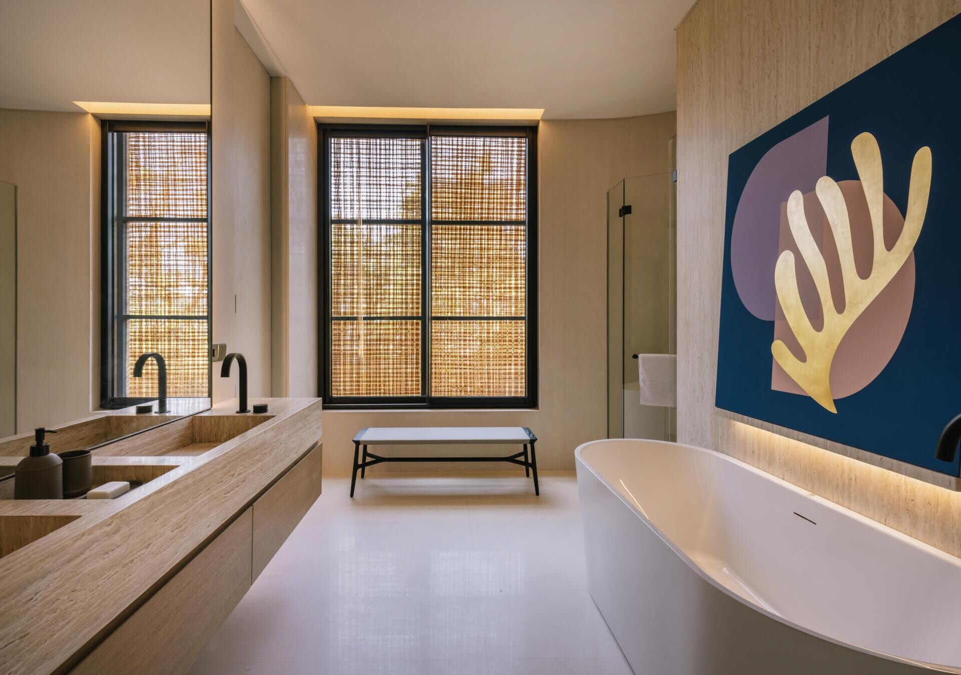 A modern primary bathroom with a high ceiling, floating double vanity, bathtub, and separate shower.