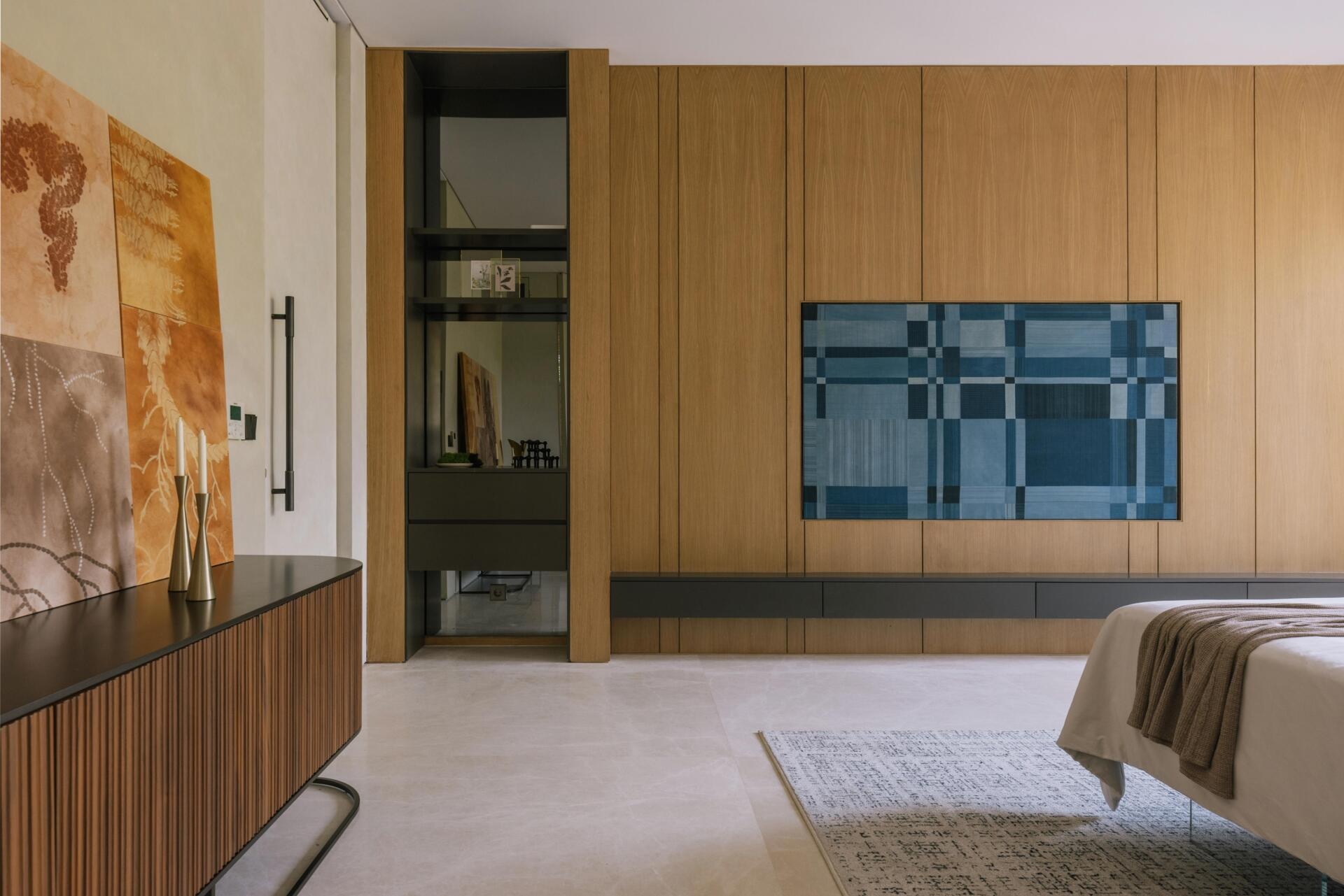A modern primary bedroom with a wood accent wall.