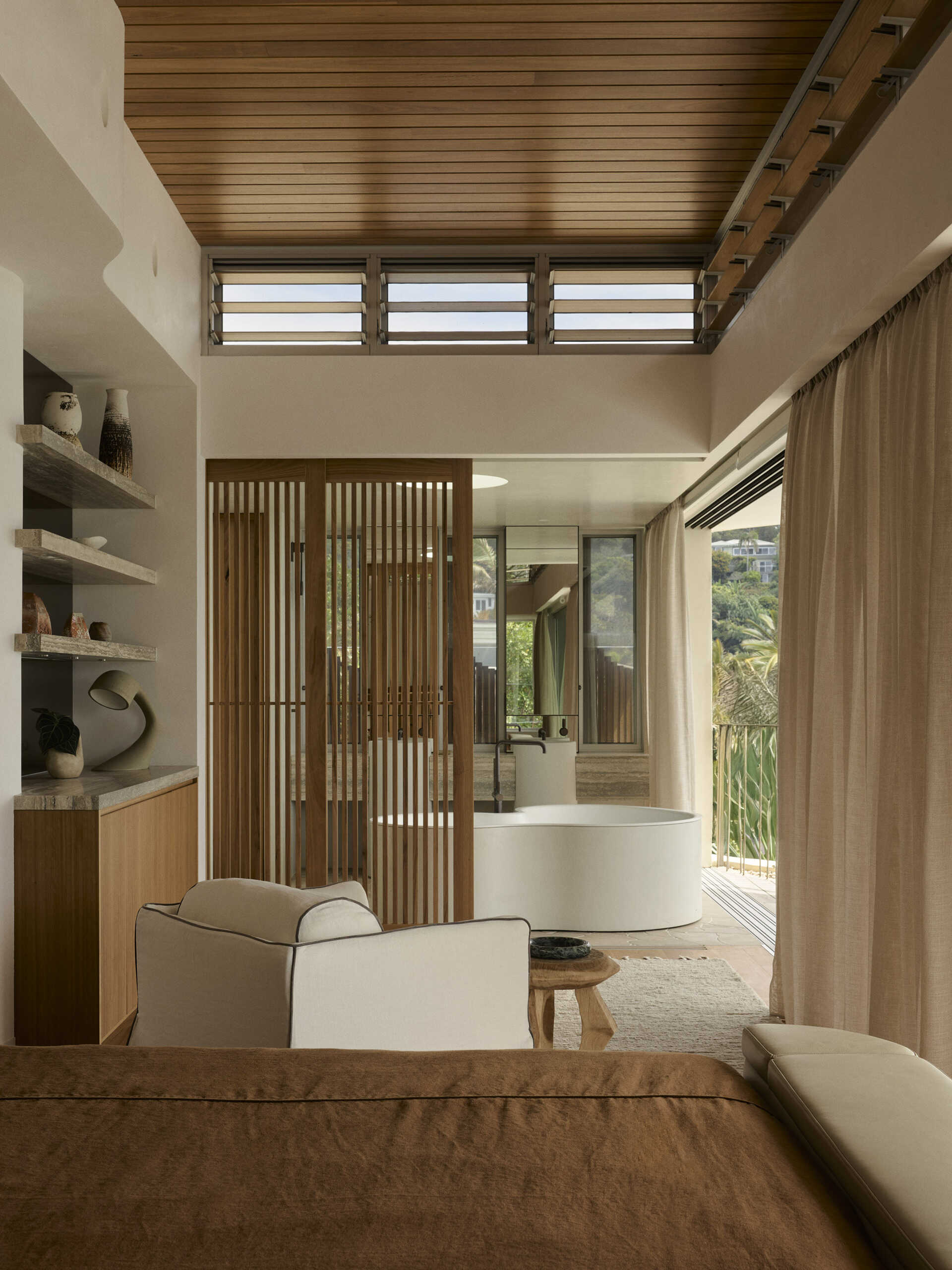 Inside this luxurious Byron Bay ensuite, an organically shaped Agape bath, curved shower and expansive glazing create a beautiful space overlooking the surrounding coastal landscape.
