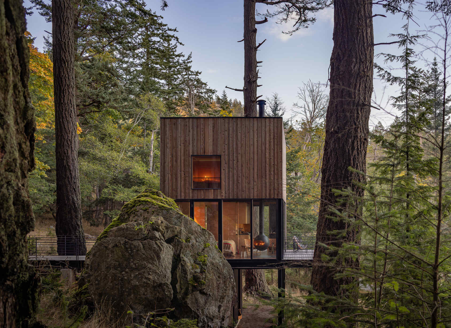 Explore the architecture of a 400-square-foot cabin suspended on stilts above the forest on Blakely Island, Washington, with a compact 16-by-20-foot footprint and expansive water views.