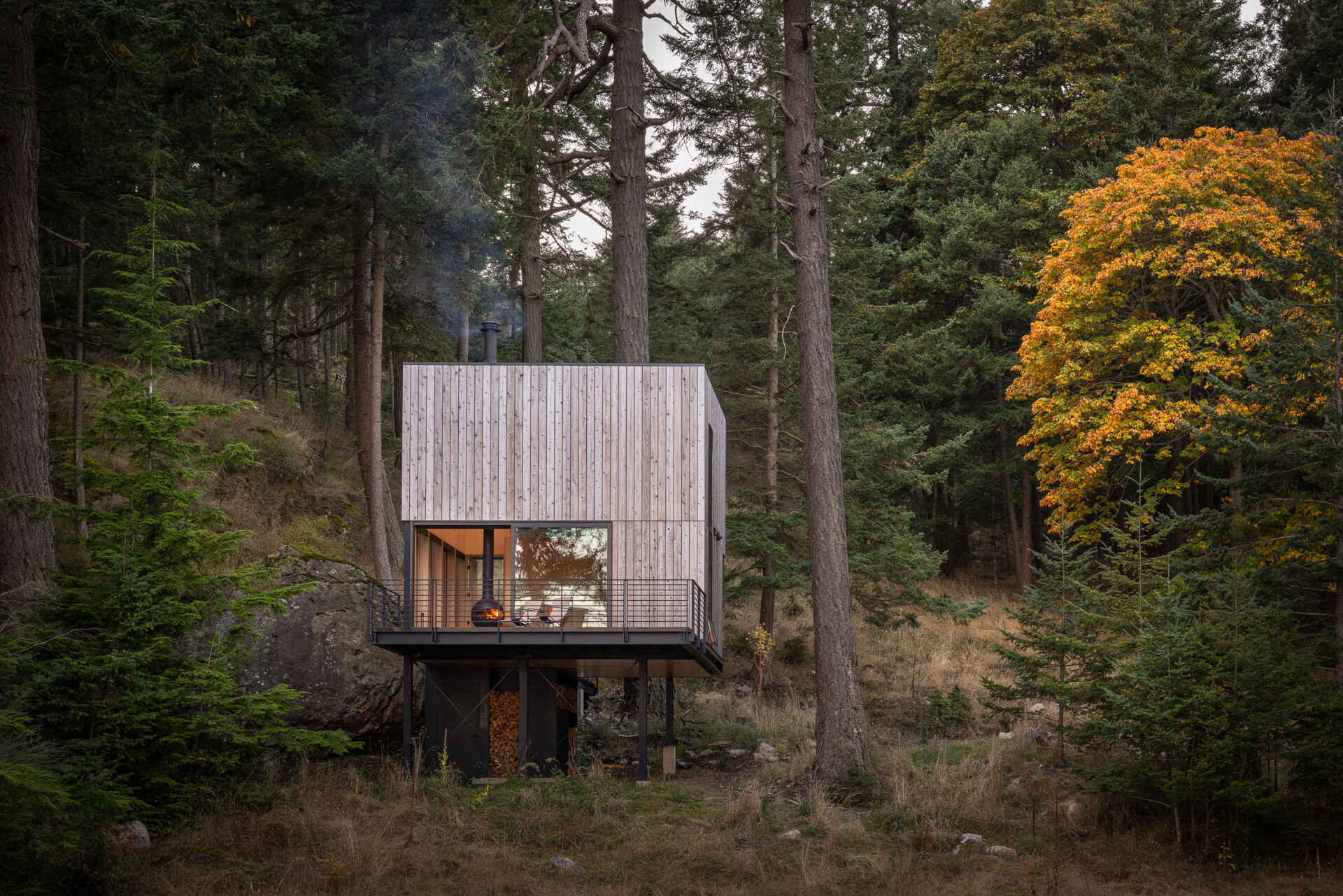 Explore the architecture of a 400-square-foot cabin suspended on stilts above the forest on Blakely Island, Washington, with a compact 16-by-20-foot footprint and expansive water views.