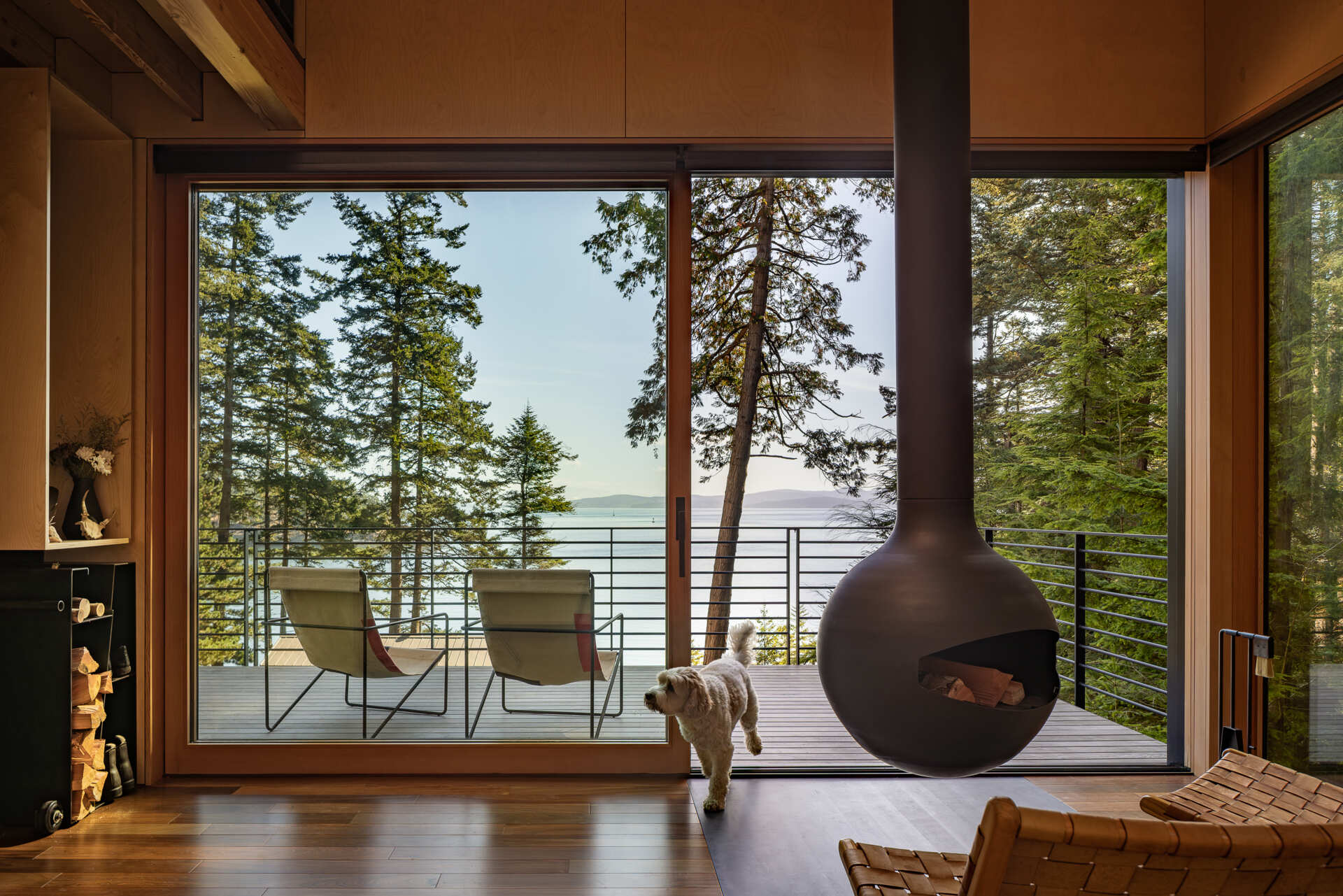 Step inside a tiny Washington cabin with birch plywood walls, fir beams, large sliding glass doors and a 360-degree rotating wood-burning fireplace overlooking the Salish Sea.