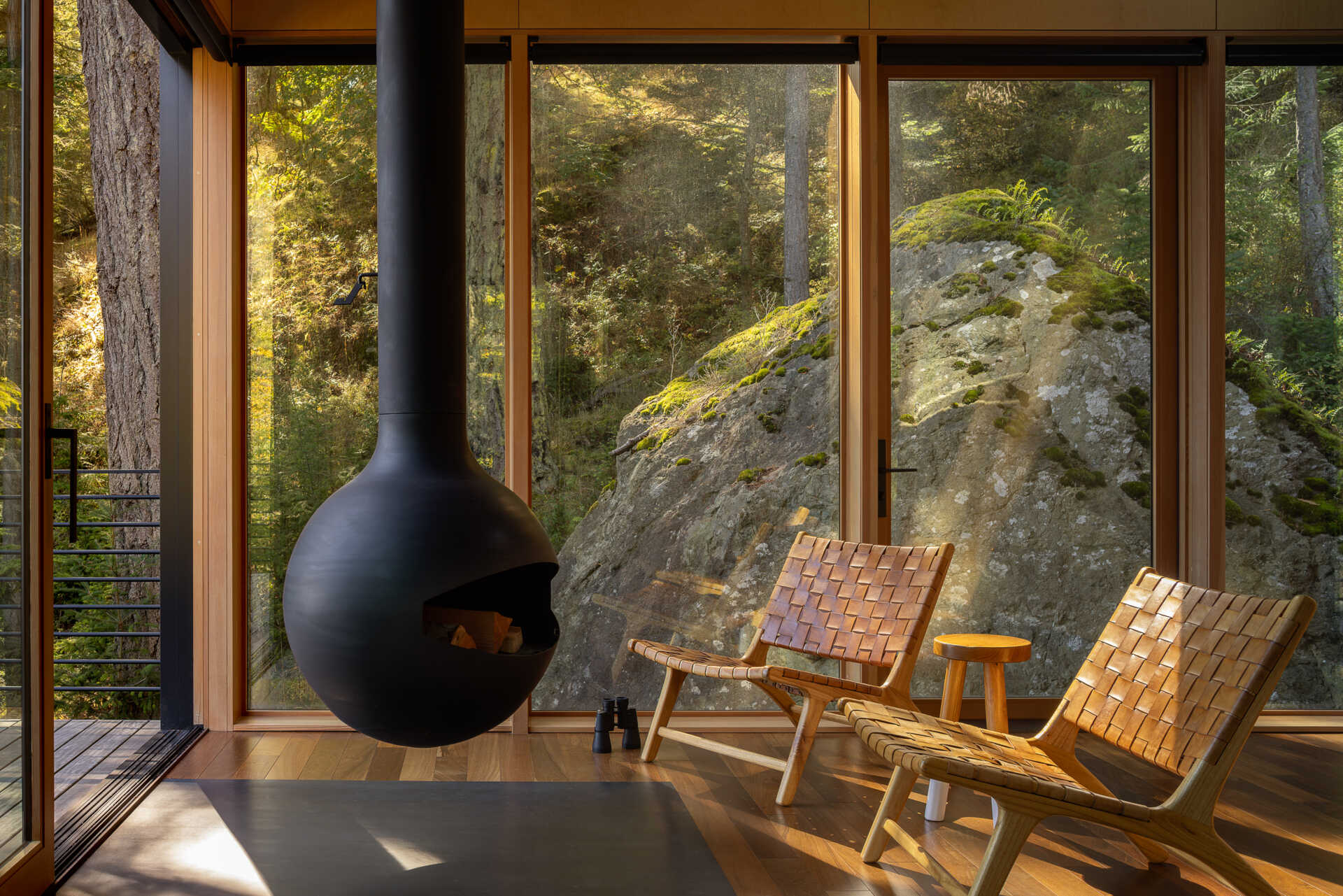 Step inside a tiny Washington cabin with birch plywood walls, fir beams, large sliding glass doors and a 360-degree rotating wood-burning fireplace overlooking the Salish Sea.