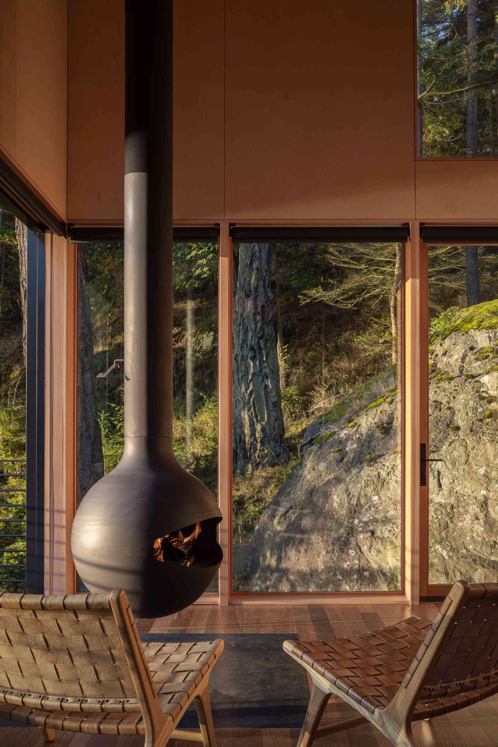 Step inside a tiny Washington cabin with birch plywood walls, fir beams, large sliding glass doors and a 360-degree rotating wood-burning fireplace overlooking the Salish Sea.