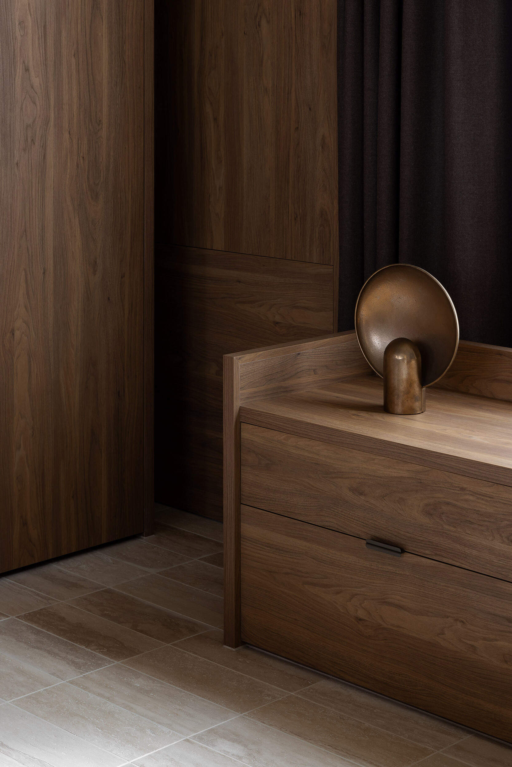 Warm timber cabinetry, bentwood chairs, a dark dining table and an oversized white pendant define Casa Piva’s dining area, with the larger internal courtyard bringing daylight and planting into the living spaces.