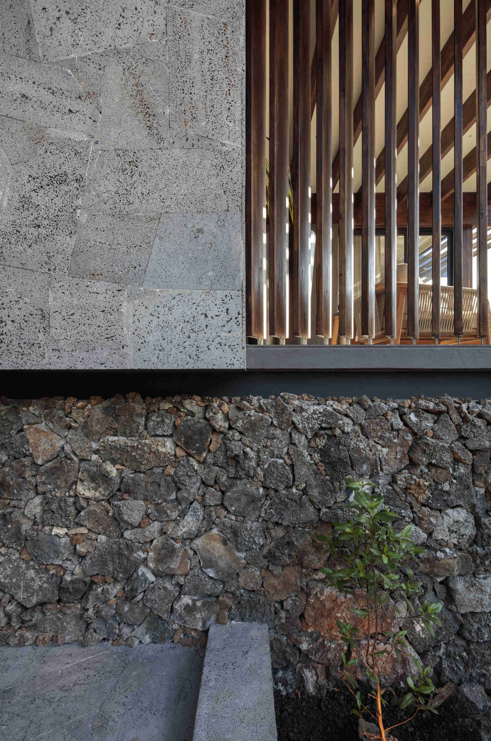 Explore the Finch Bay Galápagos Hotel expansion near Puerto Ayora, Ecuador, by Alfredo Ribadeneira Arquitectos. Prefabricated teak construction, deep roof overhangs, glass-fronted terraces, and neutral guest spaces frame views of trees and volcanic rock.