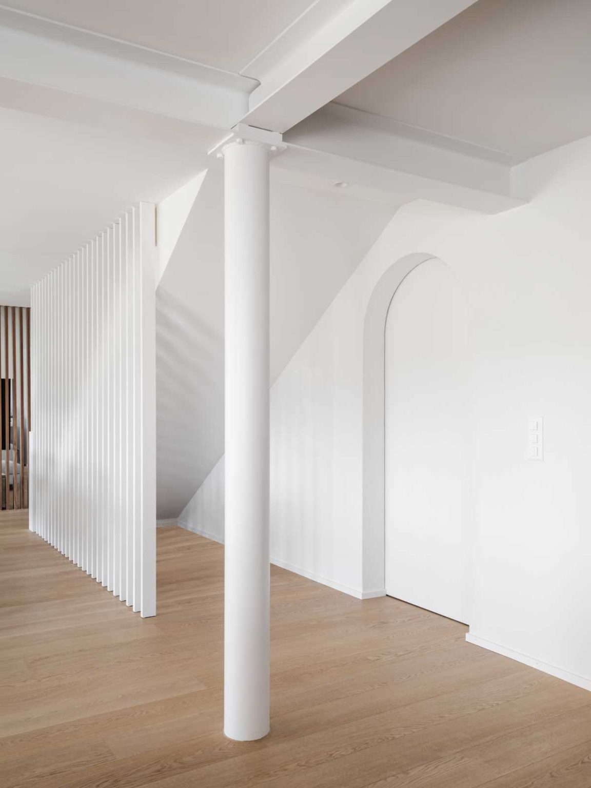 A clever under-stair room with a sink connects to a secondary living room hidden from the main communal spaces in this renovated Swiss home.