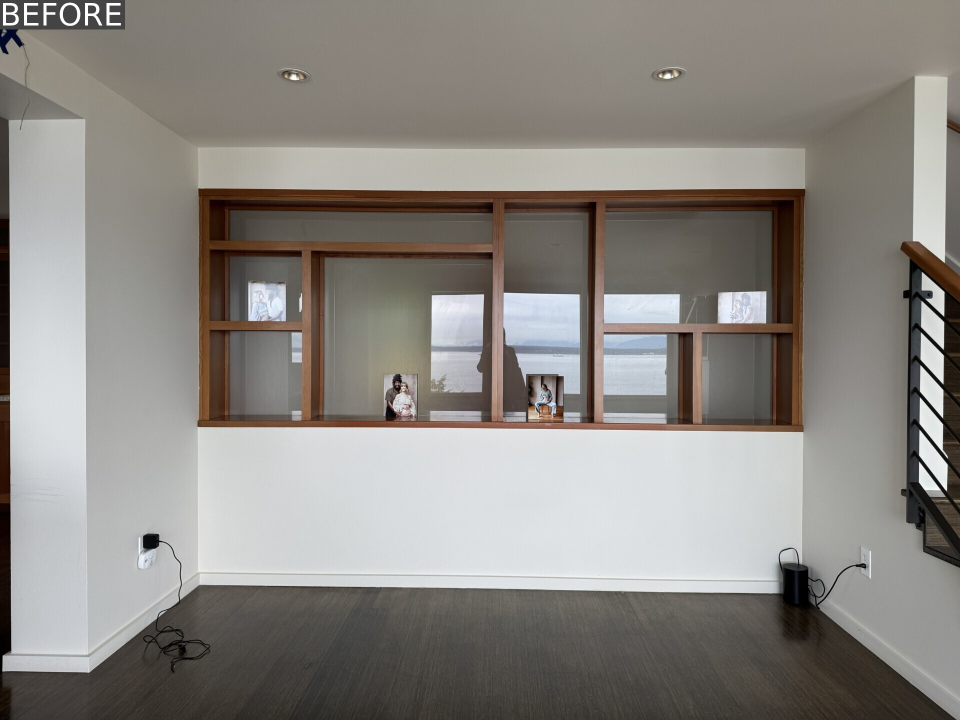 See the living room before renovation, with white walls, dark floors, timber-framed windows and an incredible Puget Sound view that had yet to become a bigger part of the room itself.
