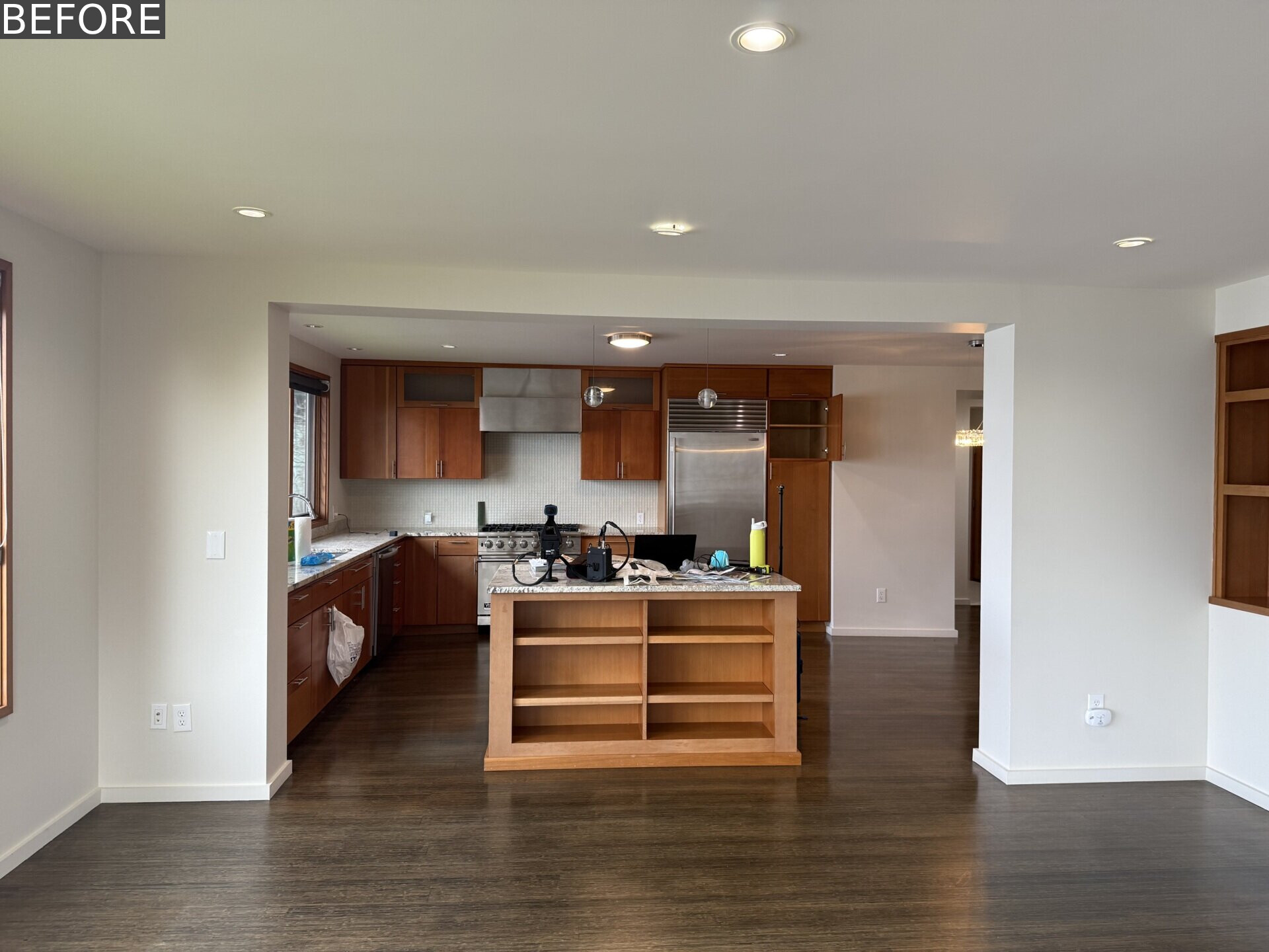 See the original kitchen at Alki Lookout, where dark timber cabinetry, granite counters and stainless-steel appliances occupied the prime window position overlooking Puget Sound.