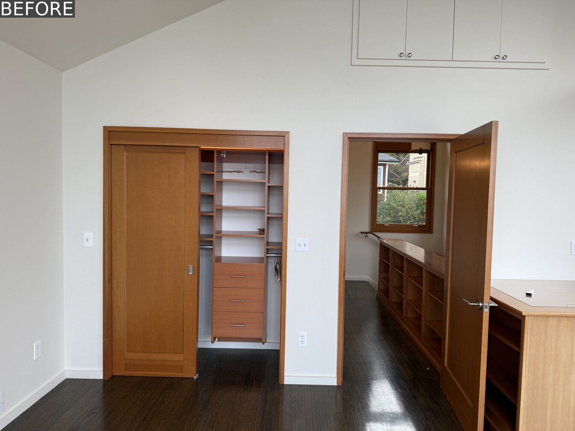 Tour the primary bedroom at Alki Lookout, where SHED paired existing panoramic Puget Sound windows with pale timber built-ins, a custom bed platform, concealed drawers and a pink-cushioned window bench.