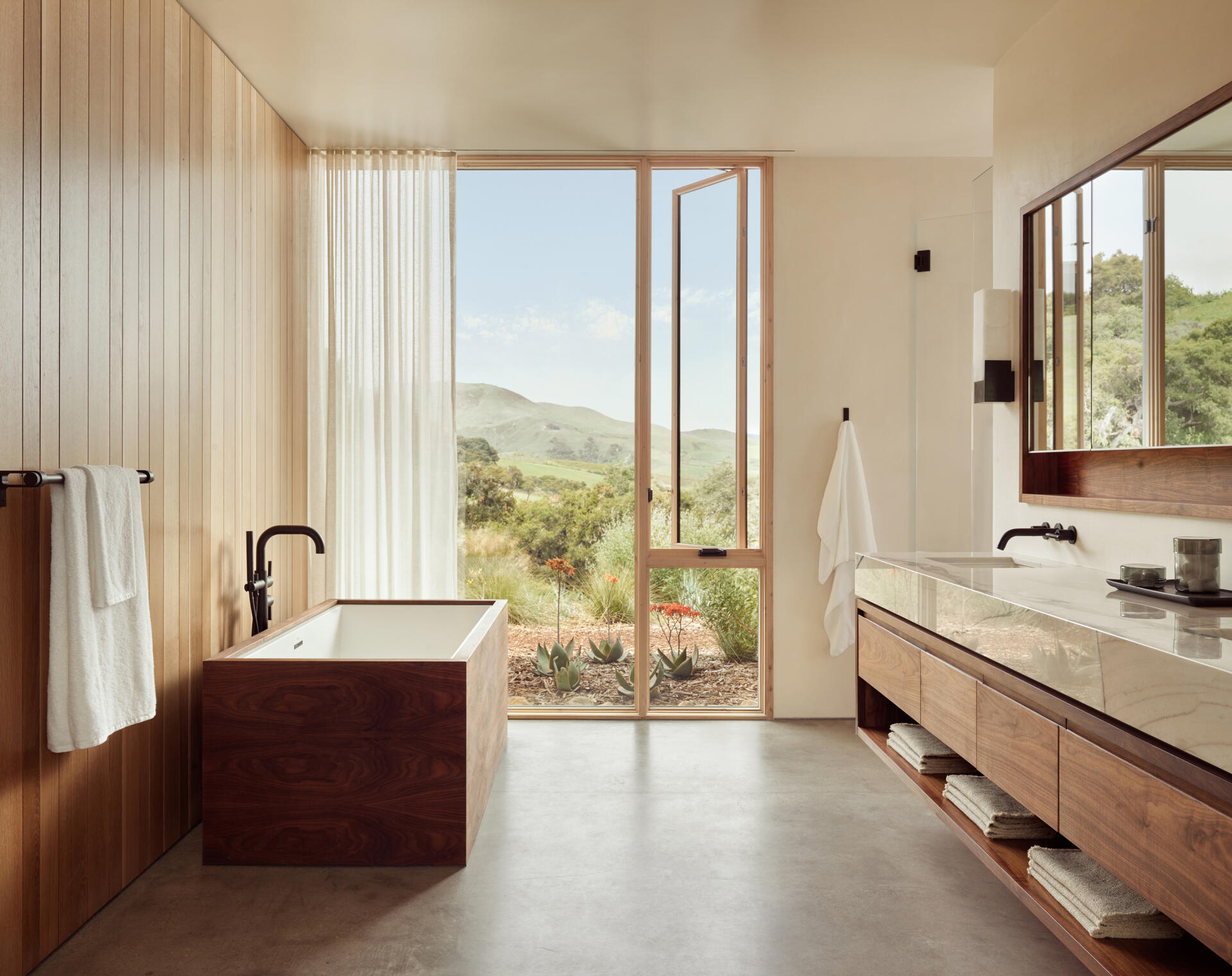 Natural materials, clean-lined finishes and understated detailing define the primary bathroom at Vineyard Residence by Clayton Korte.