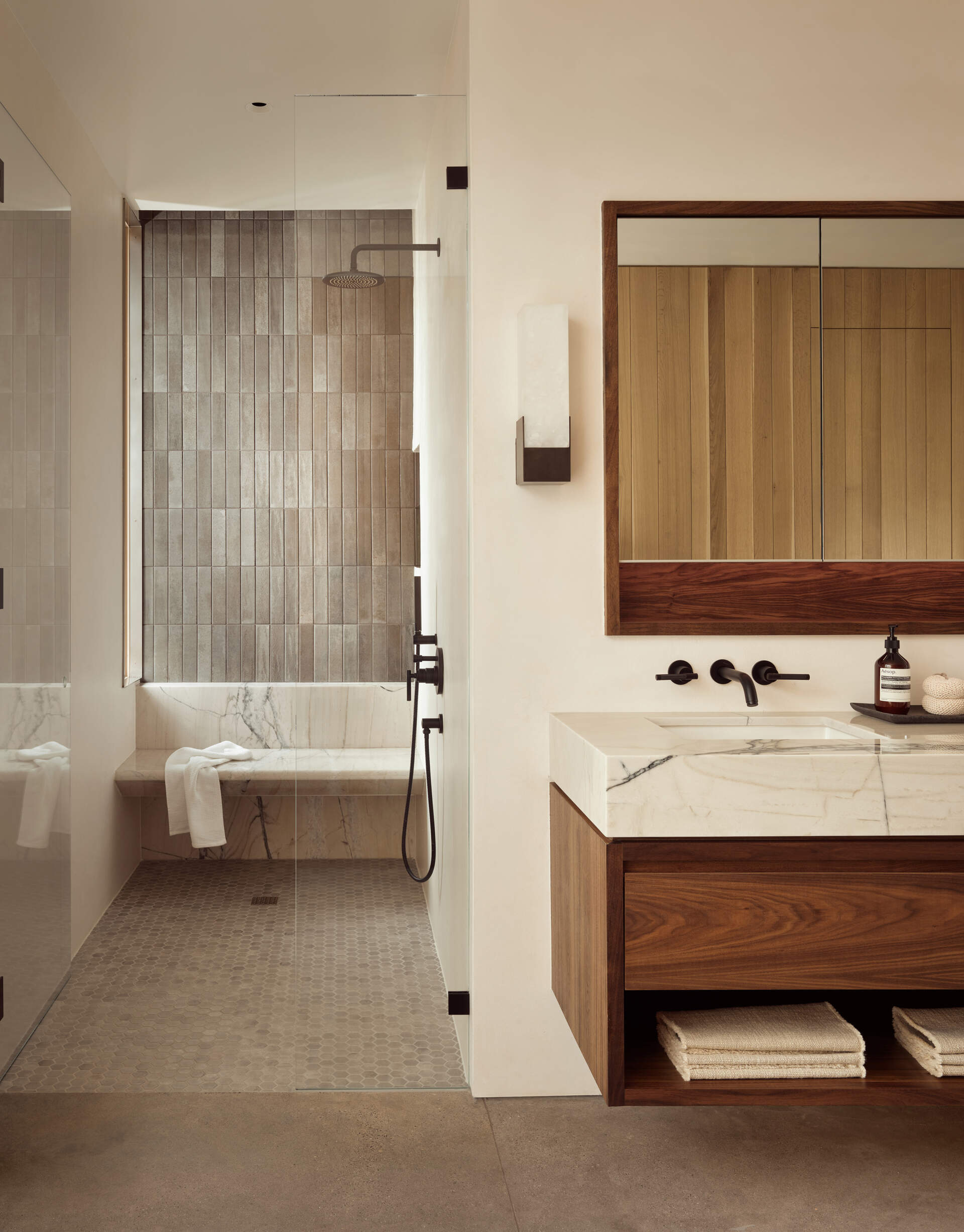 Natural materials, clean-lined finishes and understated detailing define the primary bathroom at Vineyard Residence by Clayton Korte.