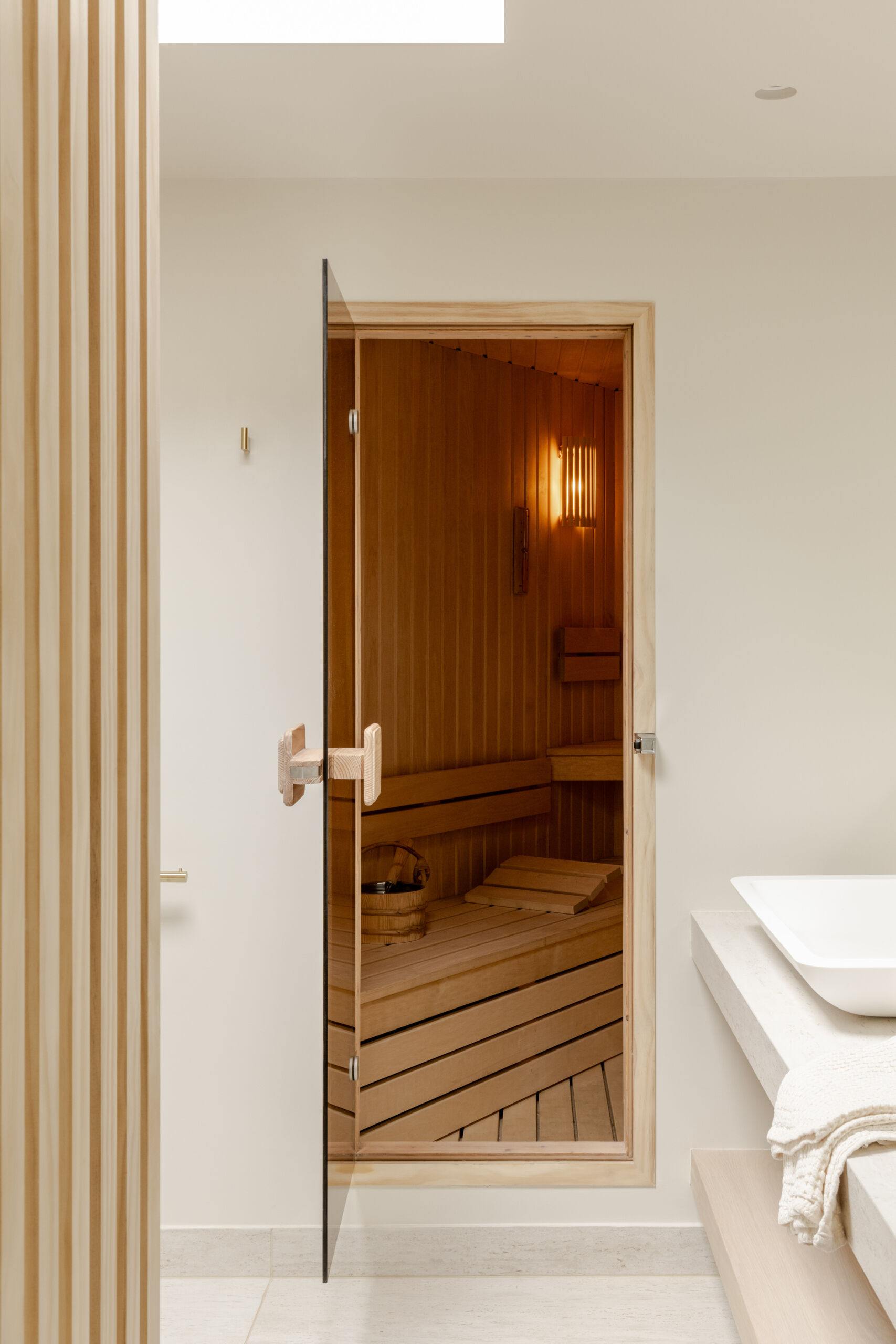 Take a look at the home gym, indoor pool and wood-lined sauna at Thirsk Cottage, combining warm timber, black equipment, skylights and glass walls.