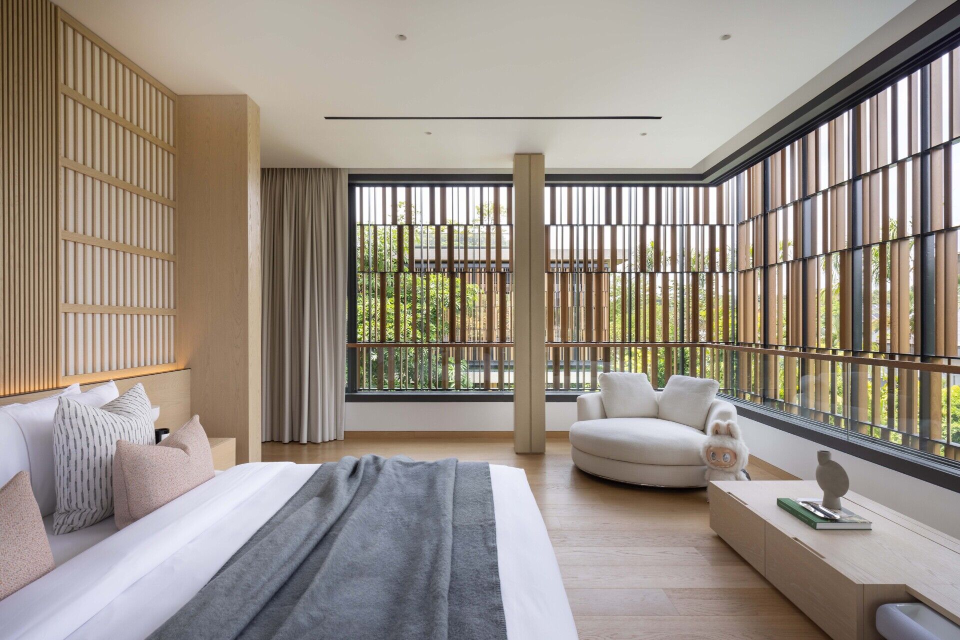 A modern bedroom with screens behind the bed, as well as around the windows.